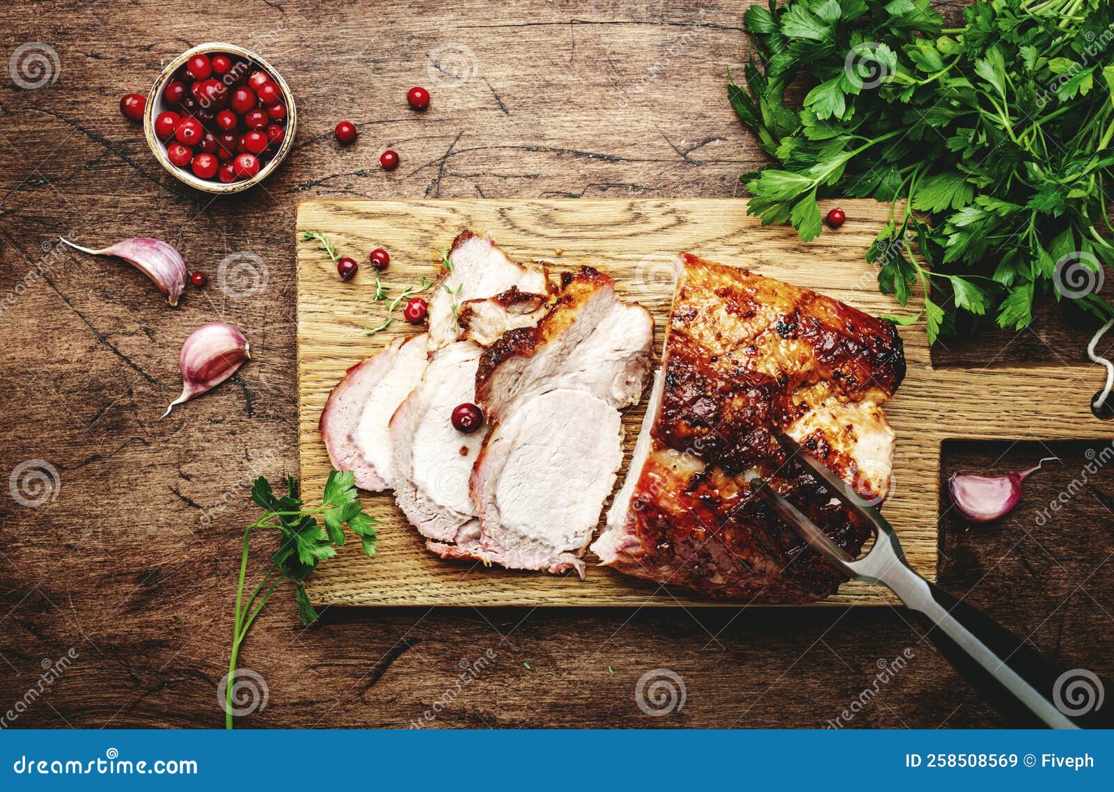 Baked Pork Loin, Whole and Cut Meat Pieces on Rustic Wooden Cutting