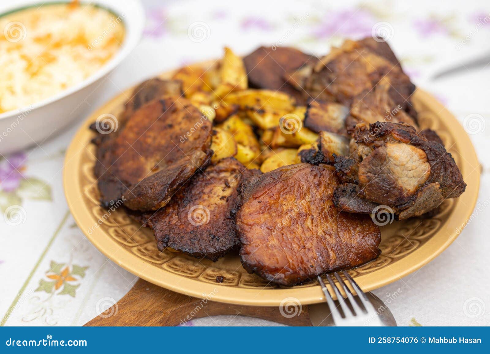 Baked Pork Ribs and Chops with Potatoes Served on the Plate Stock Photo