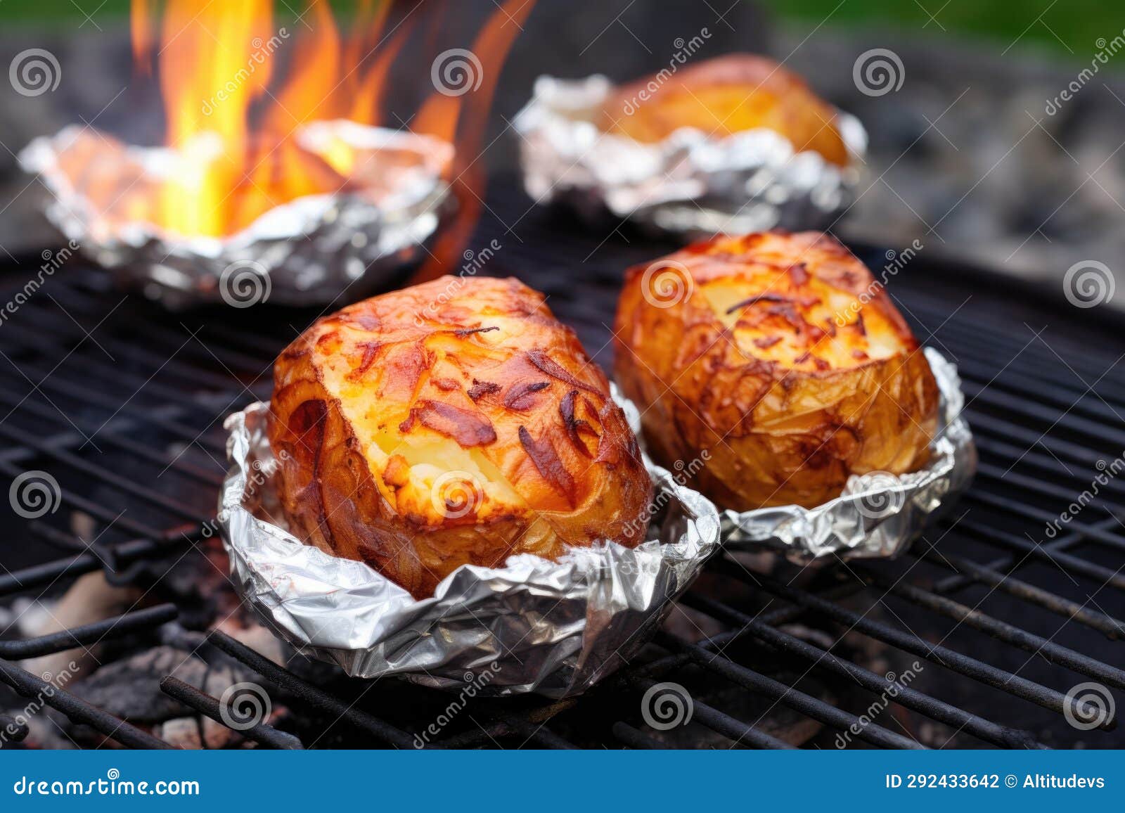 Baked Potatoes Sitting on a Rock Edge Around a Campfire Ring Stock
