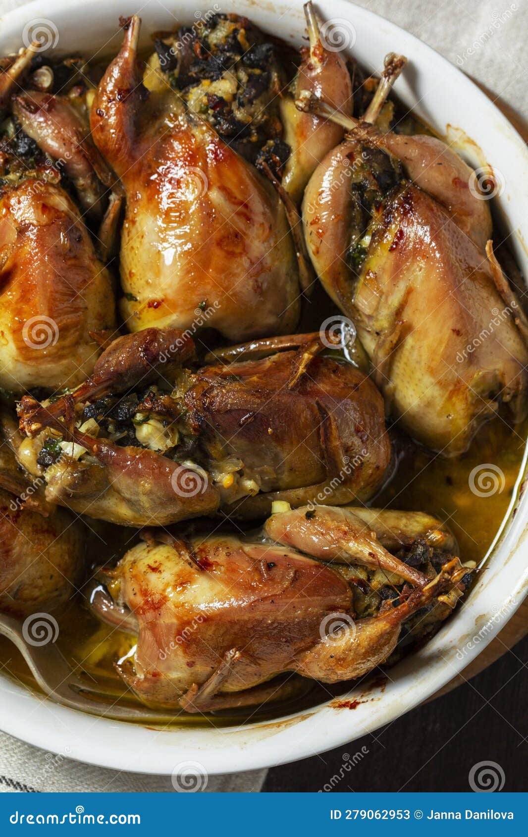Baked Quail Stuffed with Mushrooms, Eggs and Bread in a Ceramic Form on