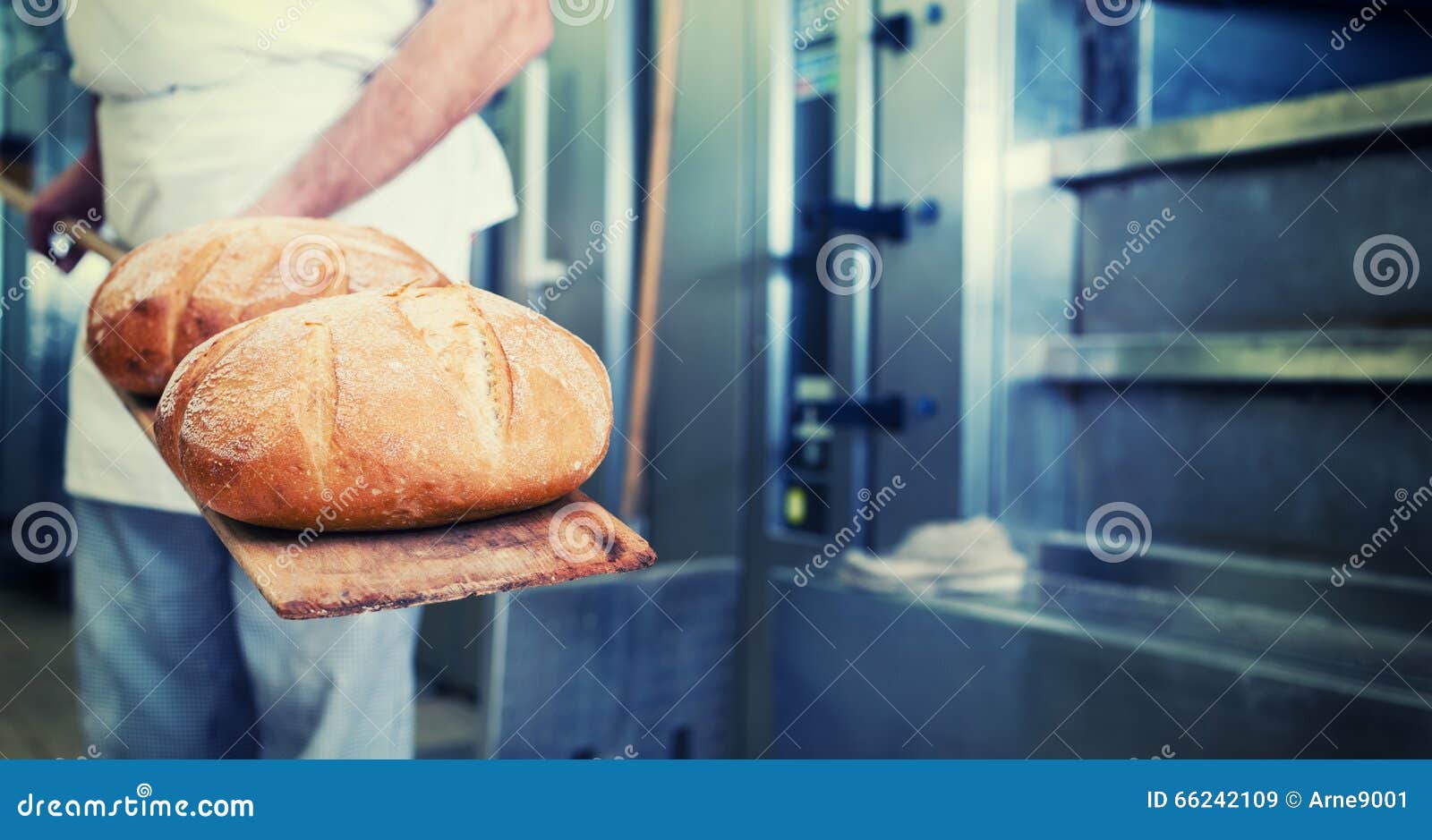 baker in bakery with bread on shovel