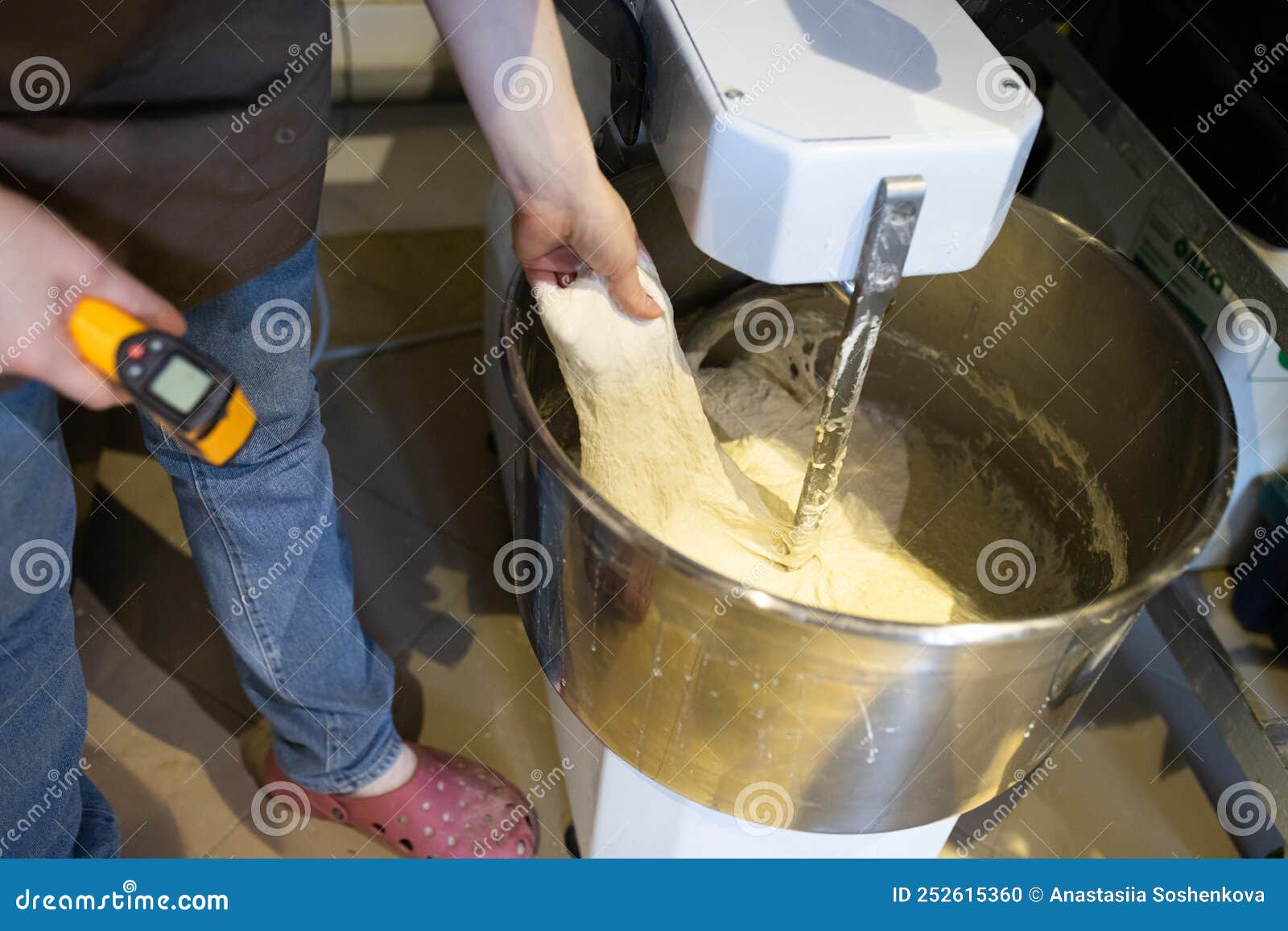 Baker Kneads Bread in a Dough Mixer. Process of Making Bread in an