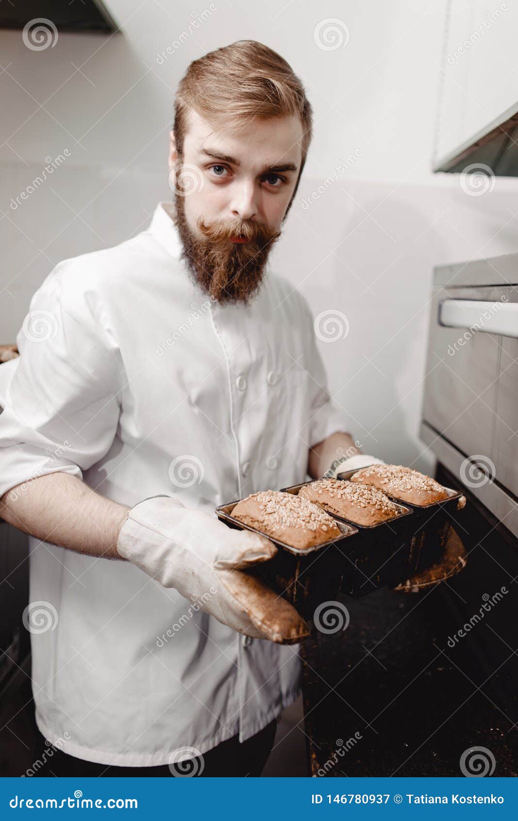 Baker Pulls Out of the Oven a Baking Sheet the Baking Tray with Newly