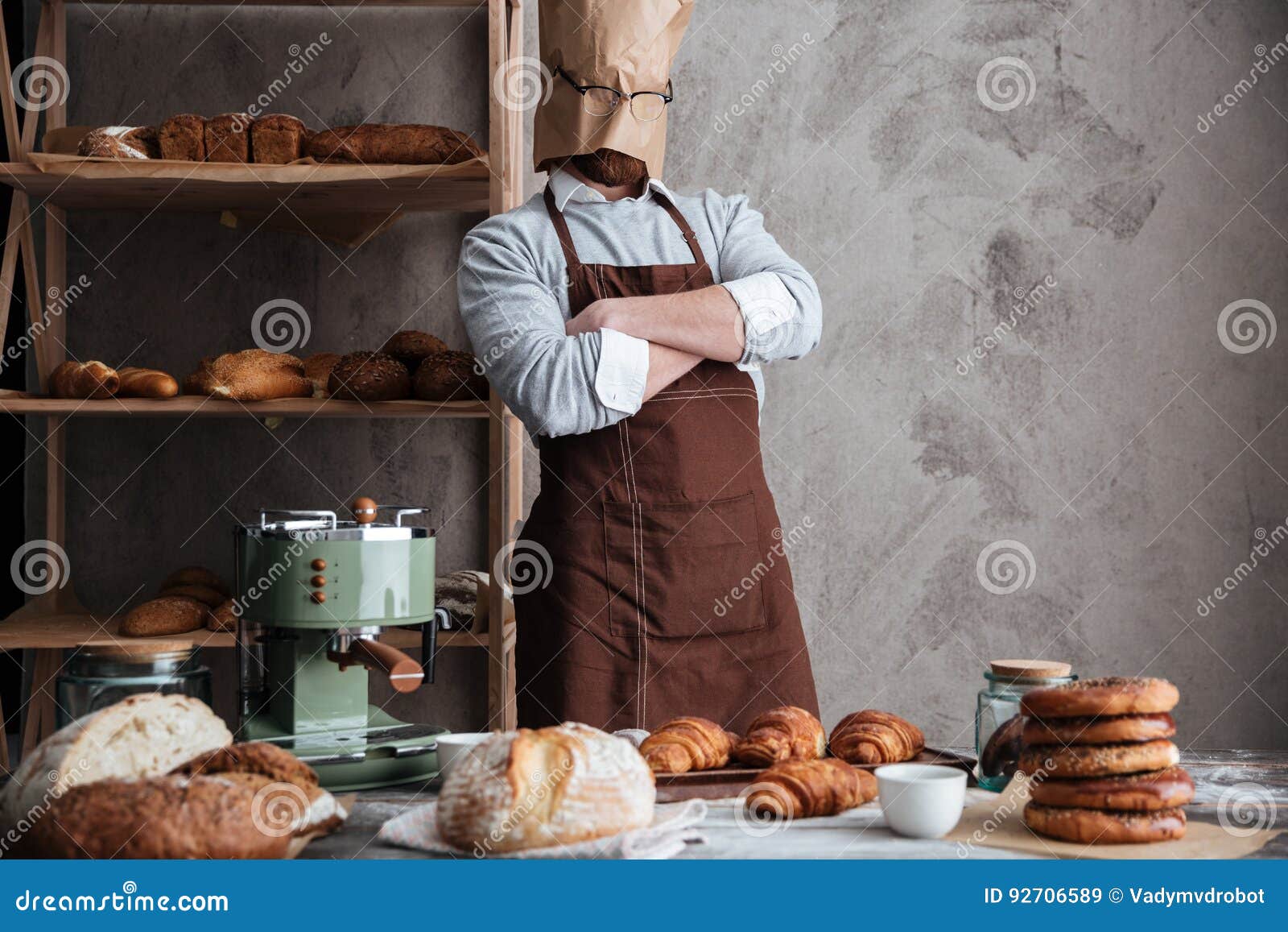 Cheerful young man baker standing at bakery holding bread Stock Photo by  vadymvdrobot