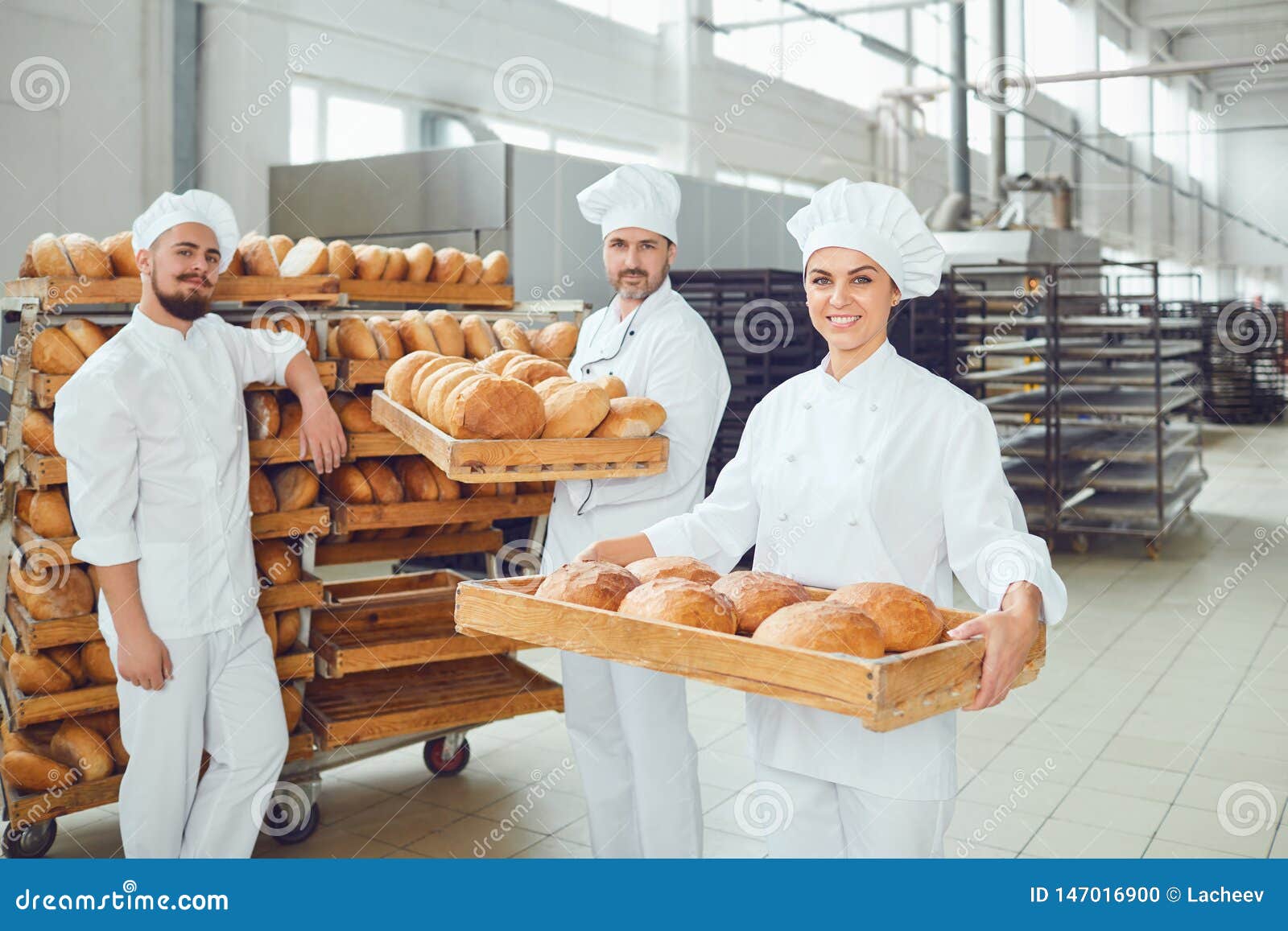 Bakers Hold a Tray with Fresh Bread in the Bakery. Stock Photo Image