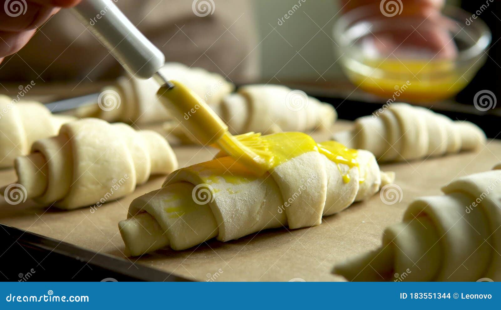 Baking Croissants at Home and Covering the Dough with Egg Yolk Using
