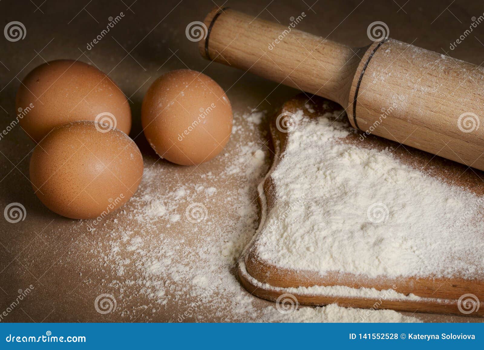 Baking Ingredients Eggs, Flour and Rolling Pin on the Table Stock Photo