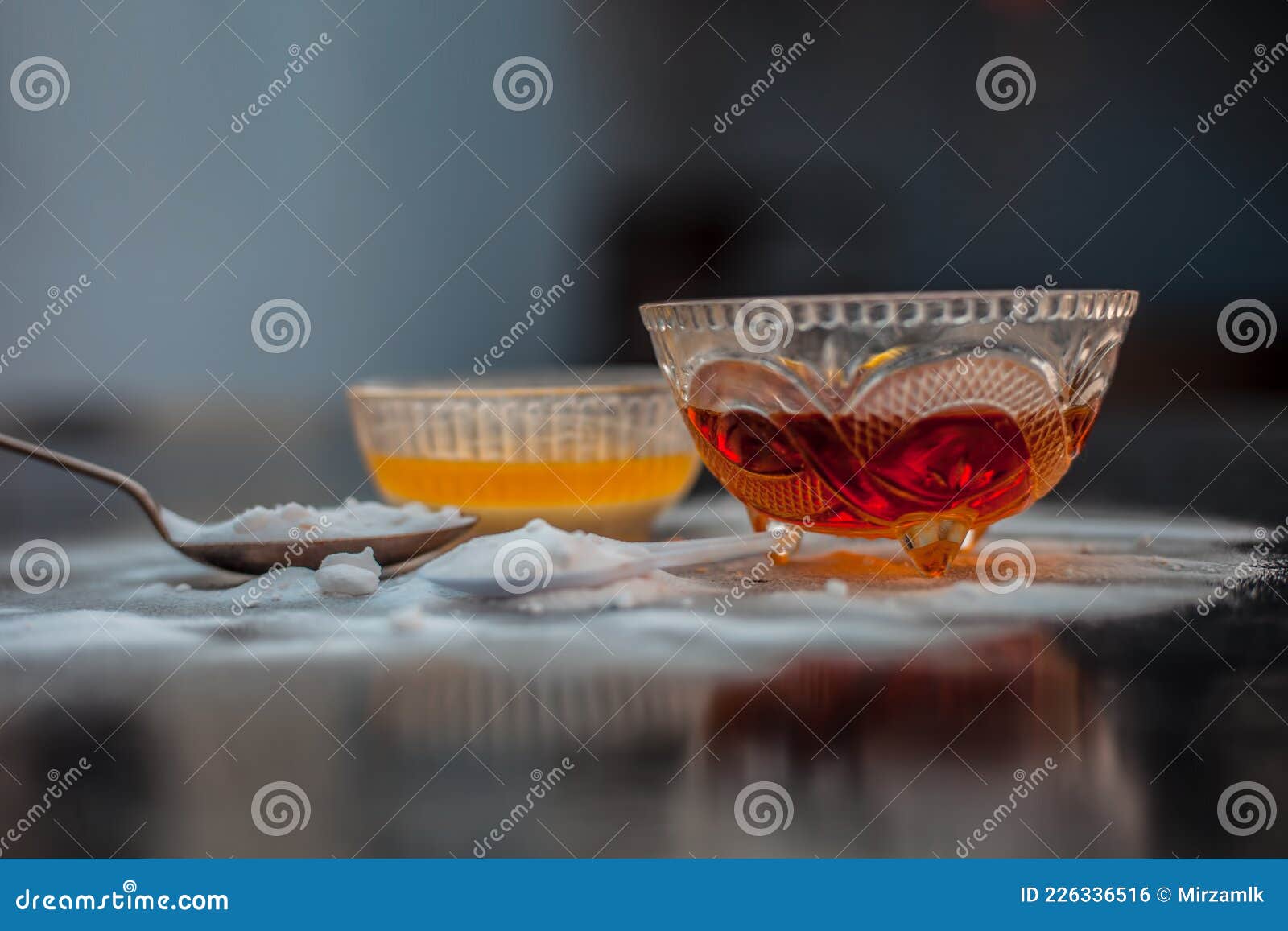 baking soda face mask in a glass bowl on wooden surface along with baking soda powder and honey
