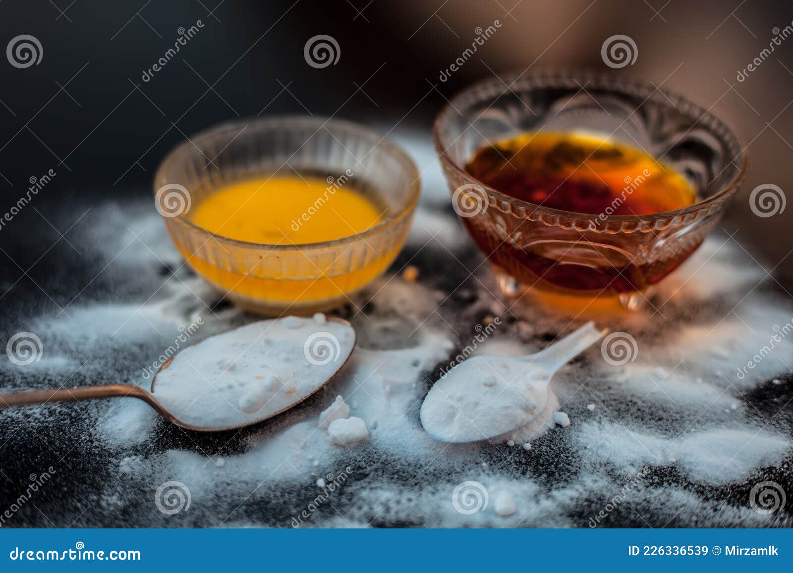 baking soda face mask in a glass bowl on wooden surface along with baking soda powder and honey