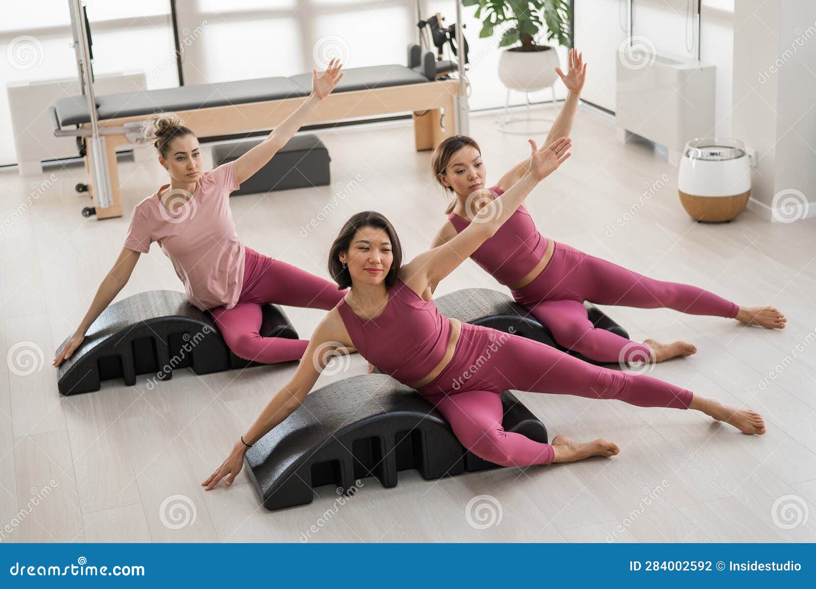 Balanced Body Pilates Arc. Three asian women exercising on pilates arc.  Stock Photo