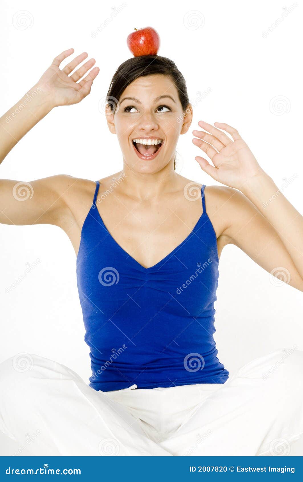 Balanced Diet. A healthy young woman balancing an apple on her head