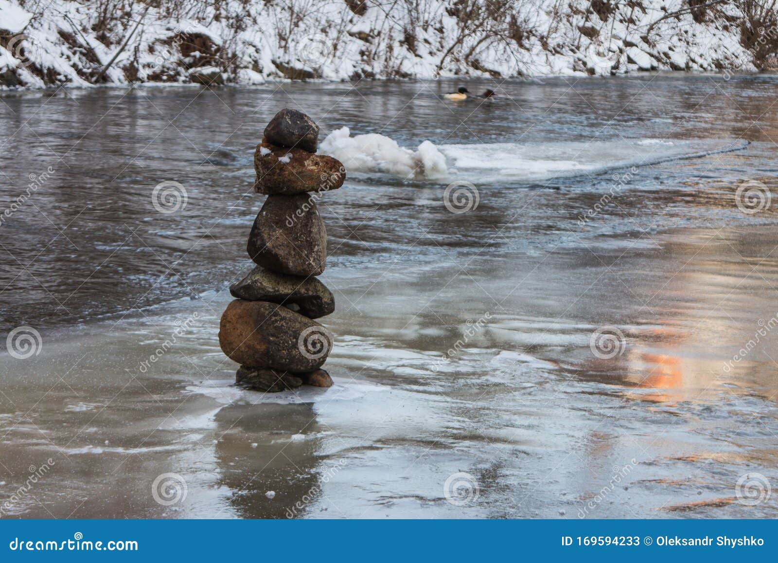 balanced stone pyramid in the middle of the river vilnia in vilnius in winter. lithuania