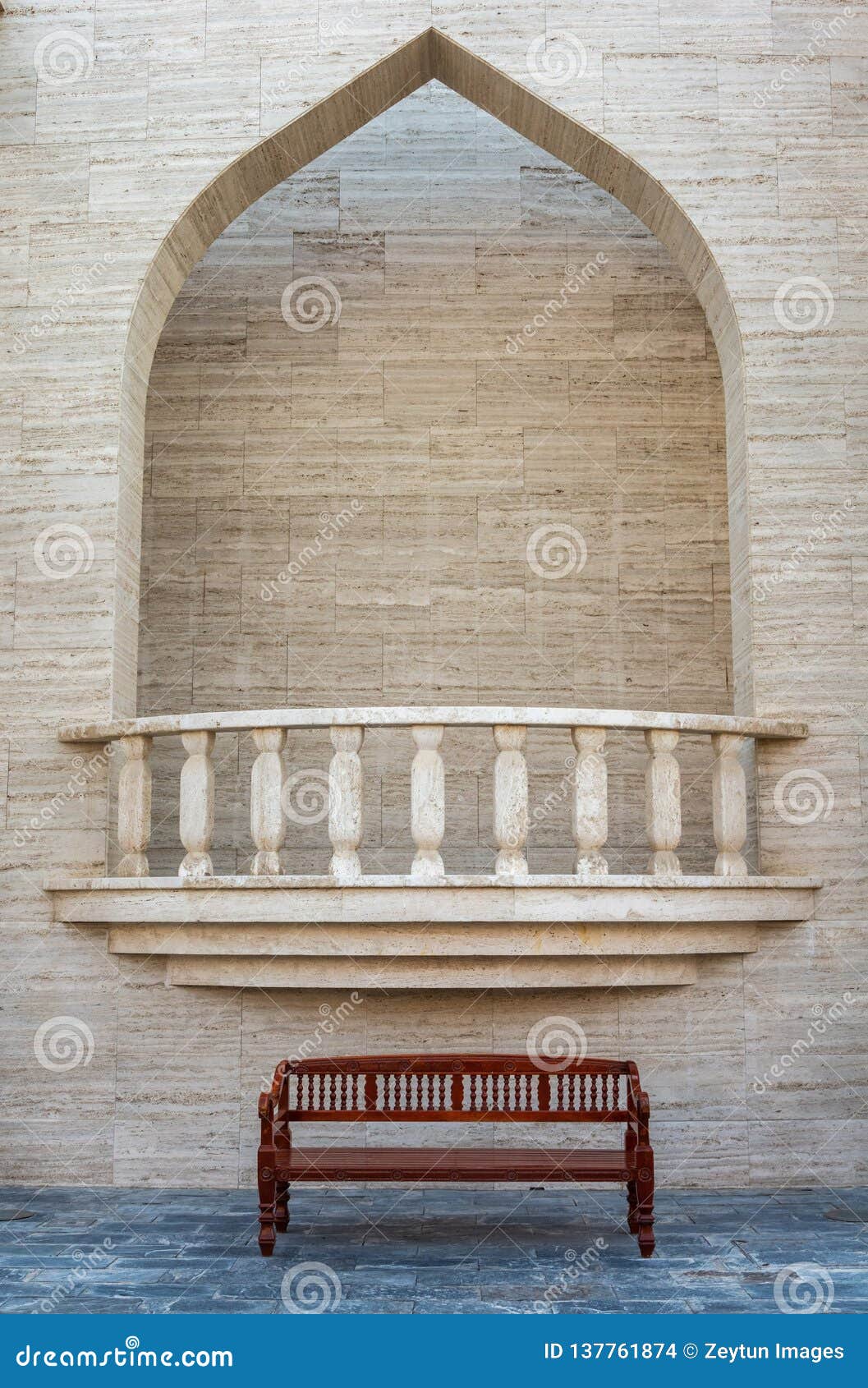 balcony with ornate opening and bench underneath