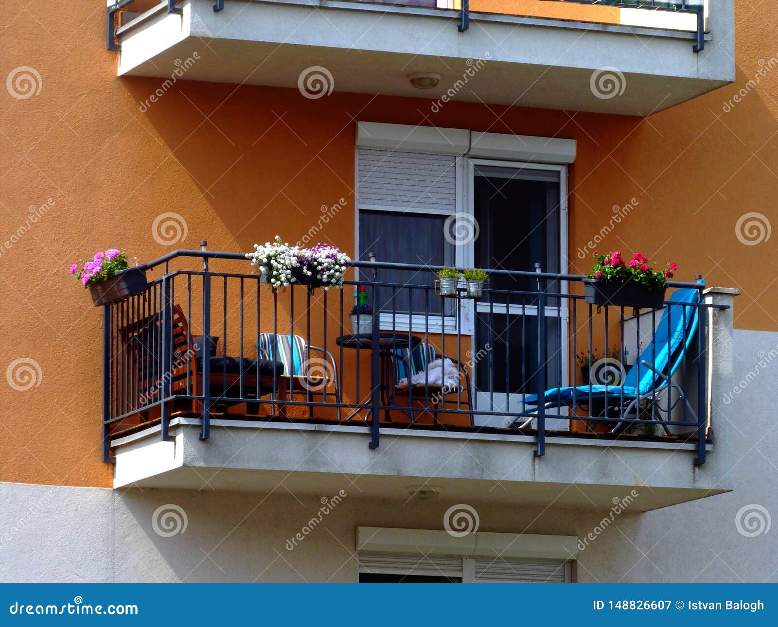 Balcony With Steel Picket Railing And Bright Patio Furniture In