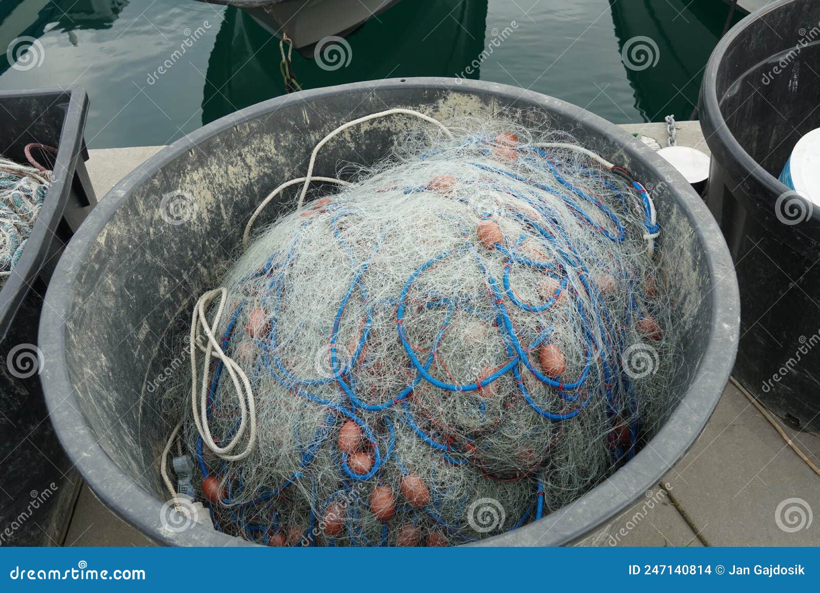 Fishing Net with Blue Ropes and Red-brown Floats Stored in Black Oval  Plastic Bucket. Stock Photo - Image of buoy, bucket: 247140814