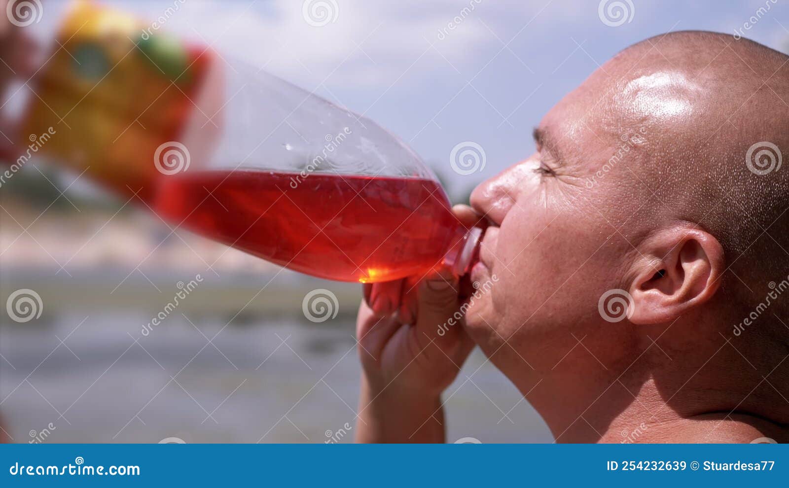 Bald Wrinkly Man Greedily Drinks Juice, Drink, Colored Water Against
