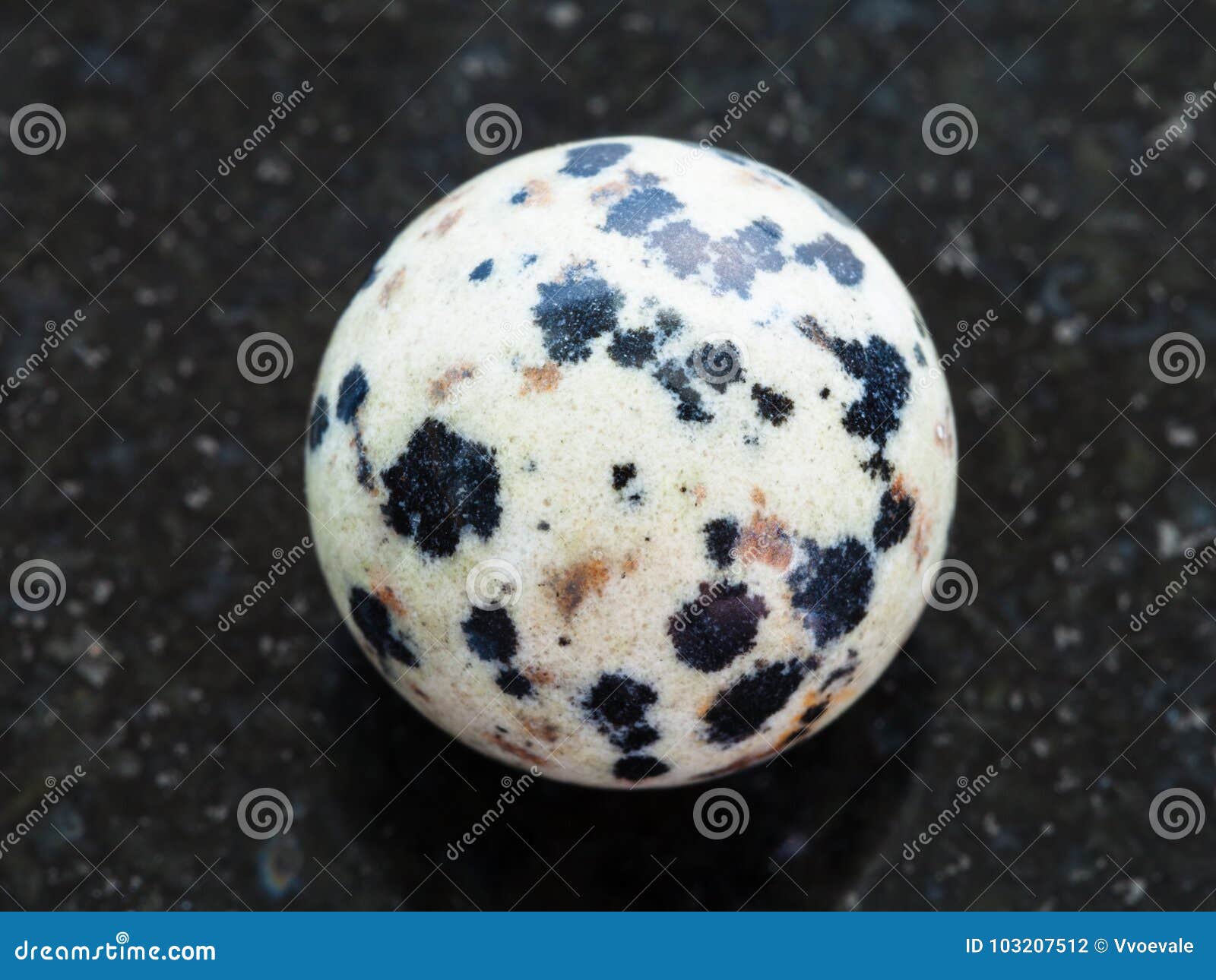 ball from dalmatian jasper gemstone on dark
