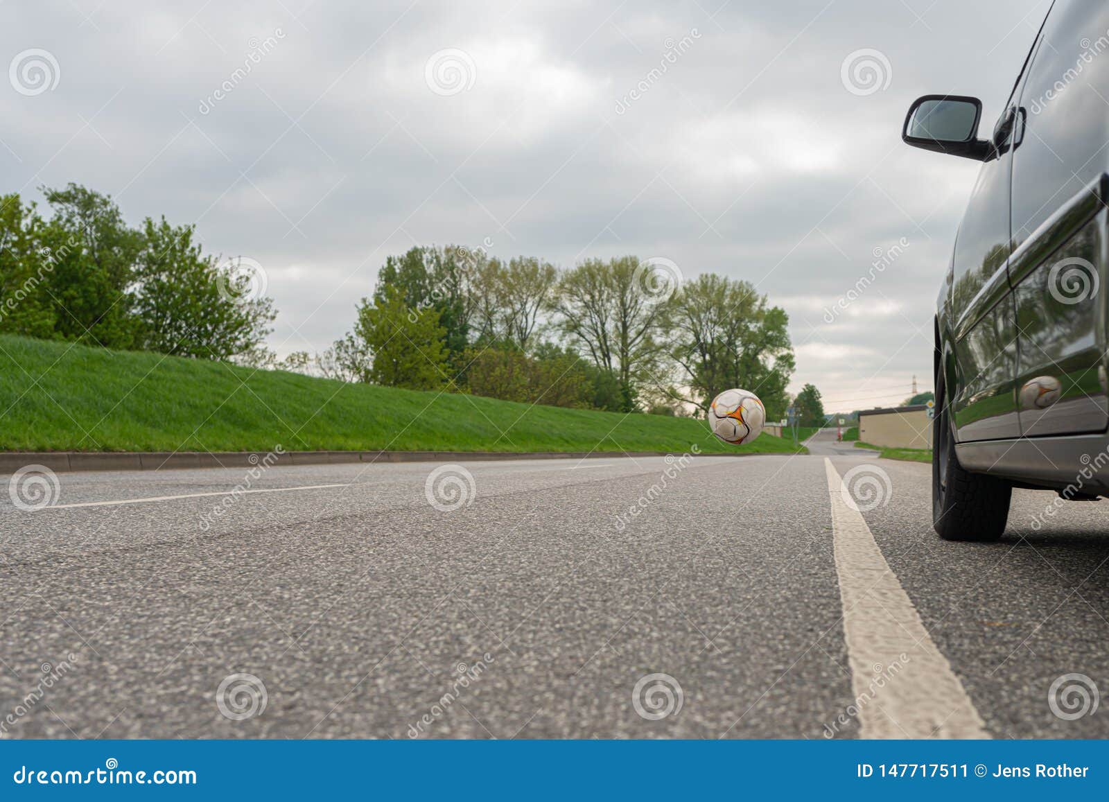 Ball Rolls Onto the Road in Front of a Car Stock Image Image of