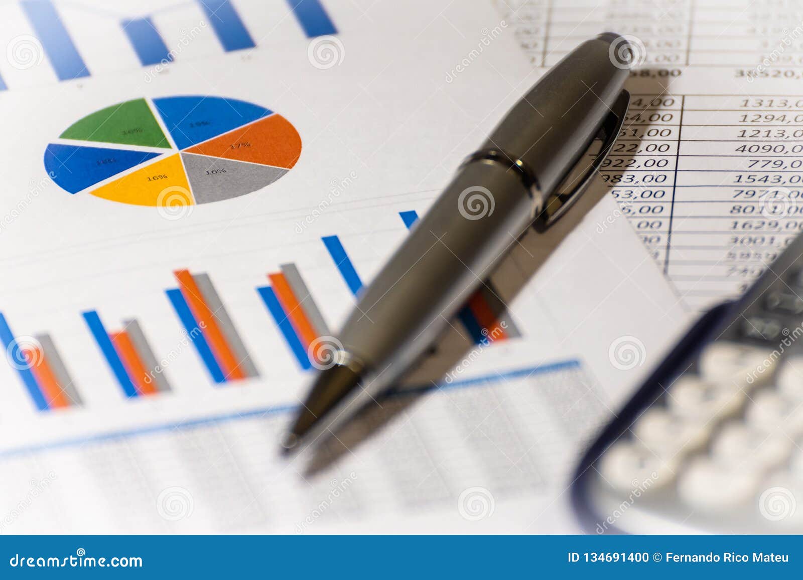 ballpoint pen, calculator and financial charts. financial reports