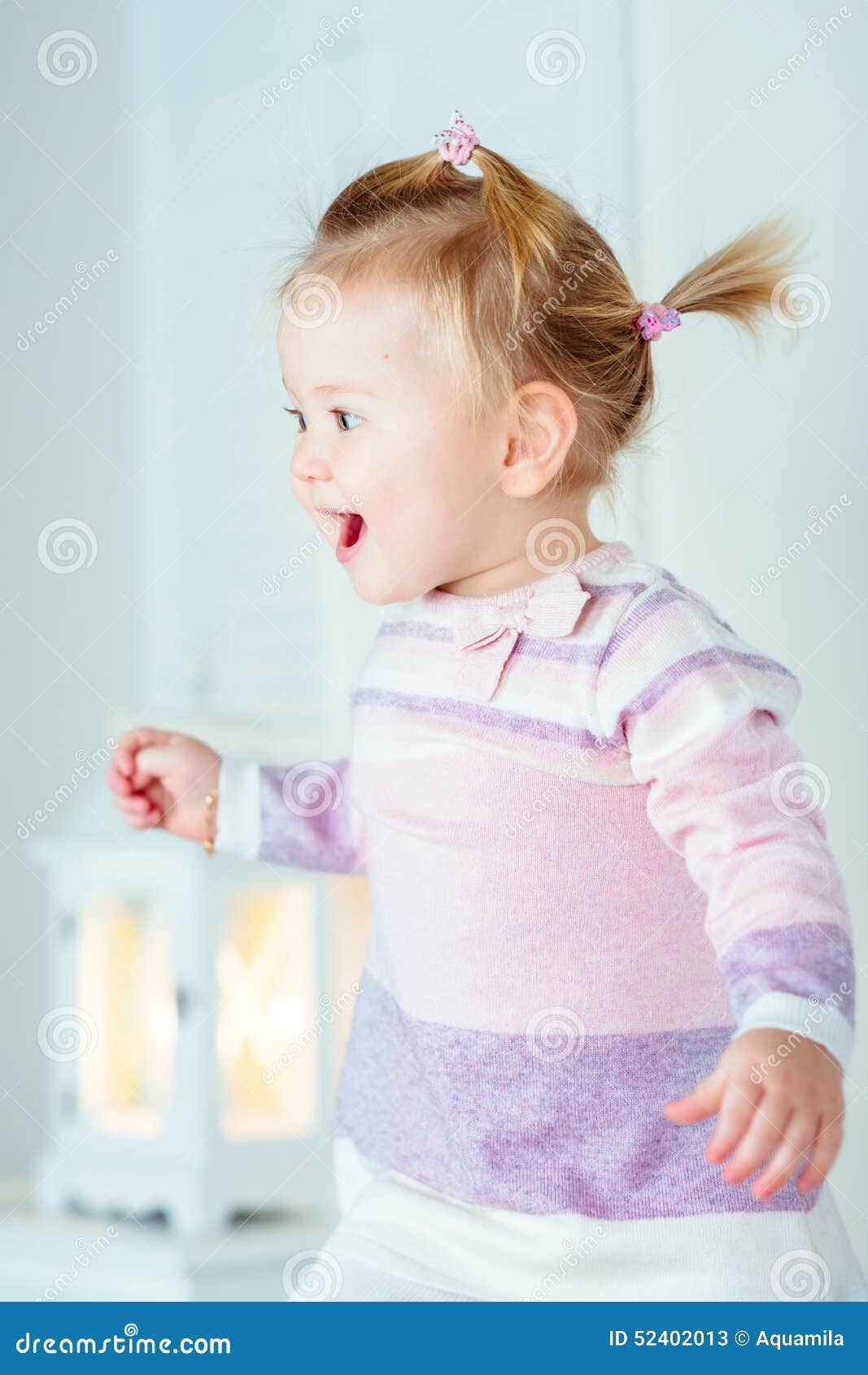 Bambina bionda emozionante con la coda di cavallo che salta sul ...