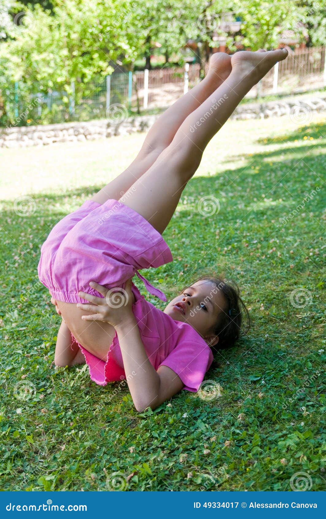 bambina che fa ginnastica sul prato