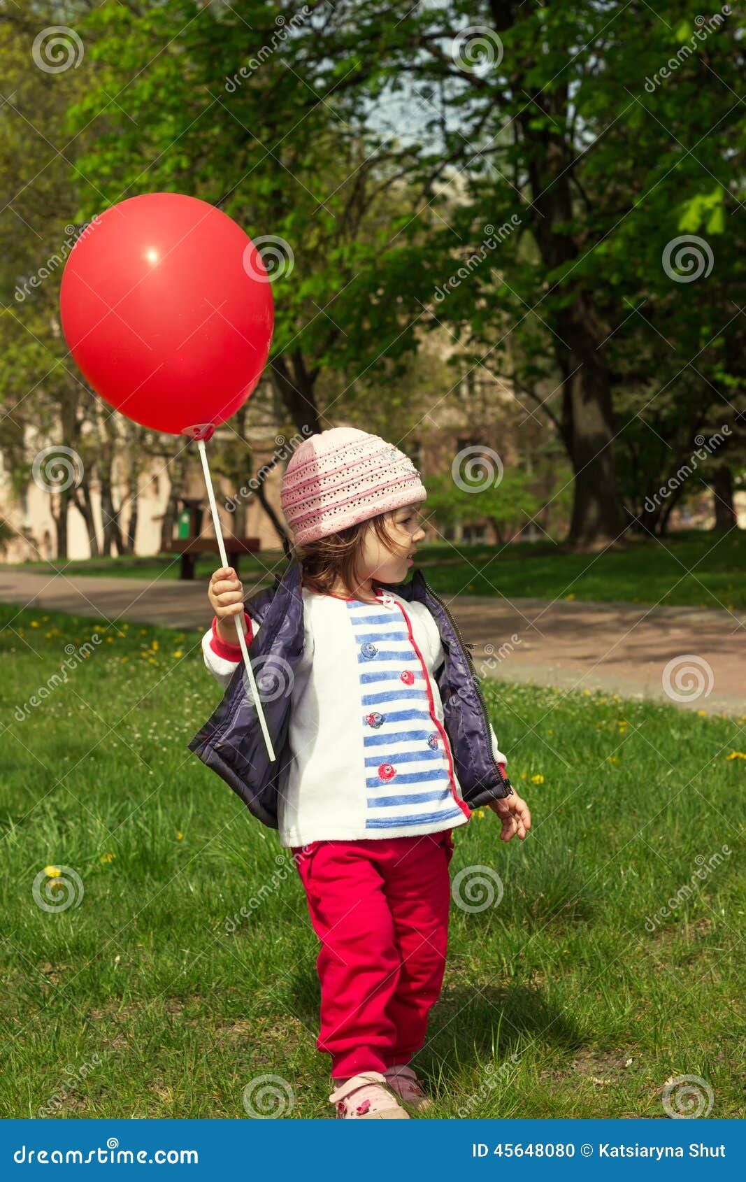 Bambina che gioca con il pallone rosso