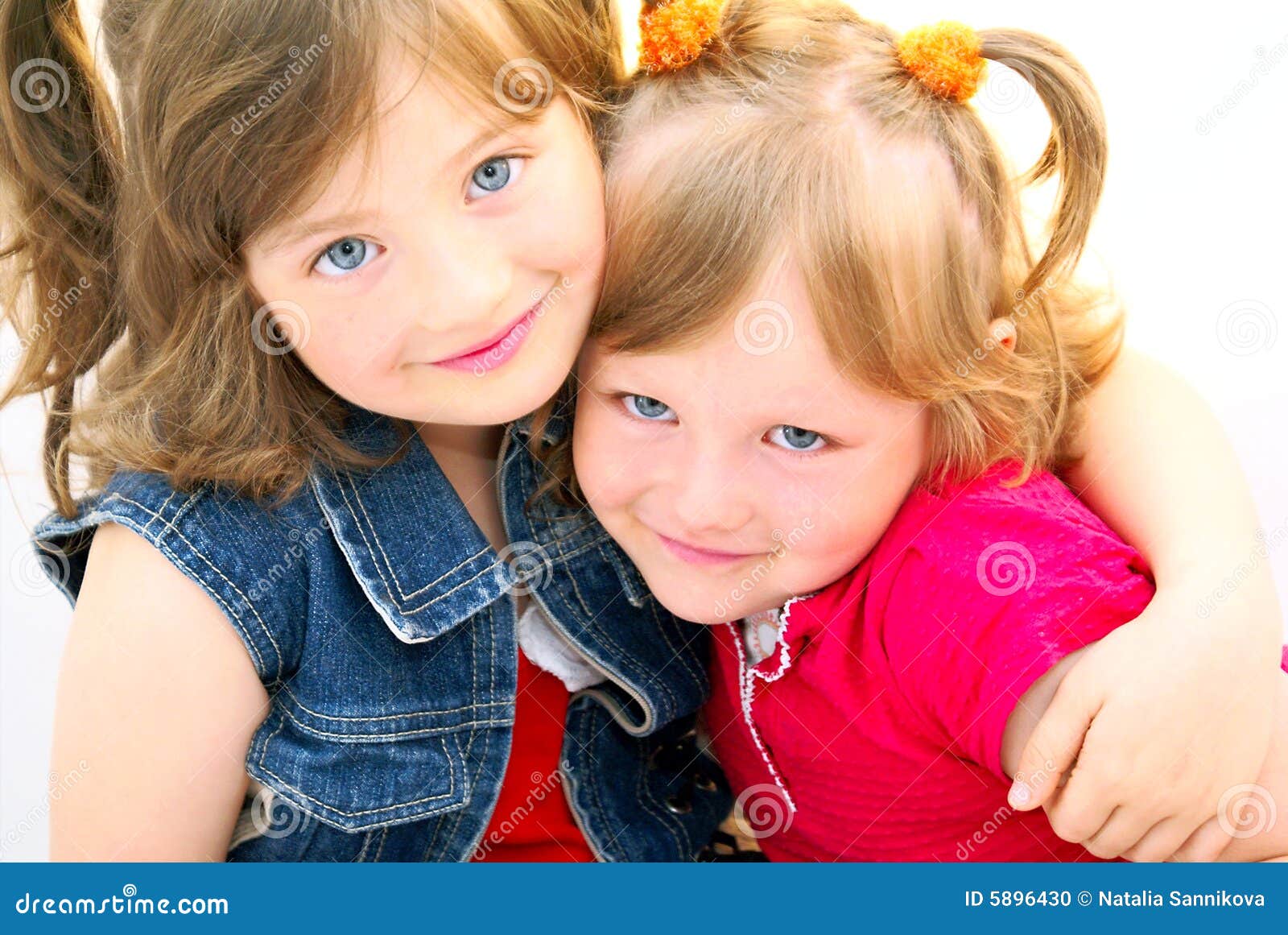 Bambini del fronte dei fratelli germani. Due giovani sorelle si siedono si sono abbracciate, i loro fronti ottengono la felicità.