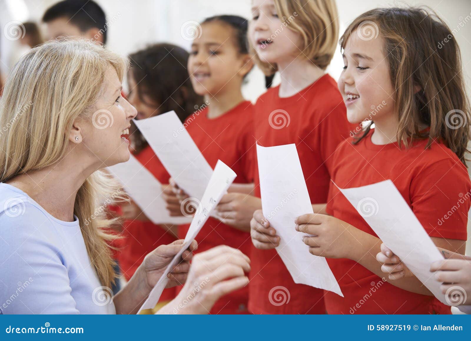 Bambini nel gruppo di canto che è incoraggiato dall'insegnante. Bambini che cantano nel gruppo che è incoraggiato dall'insegnante