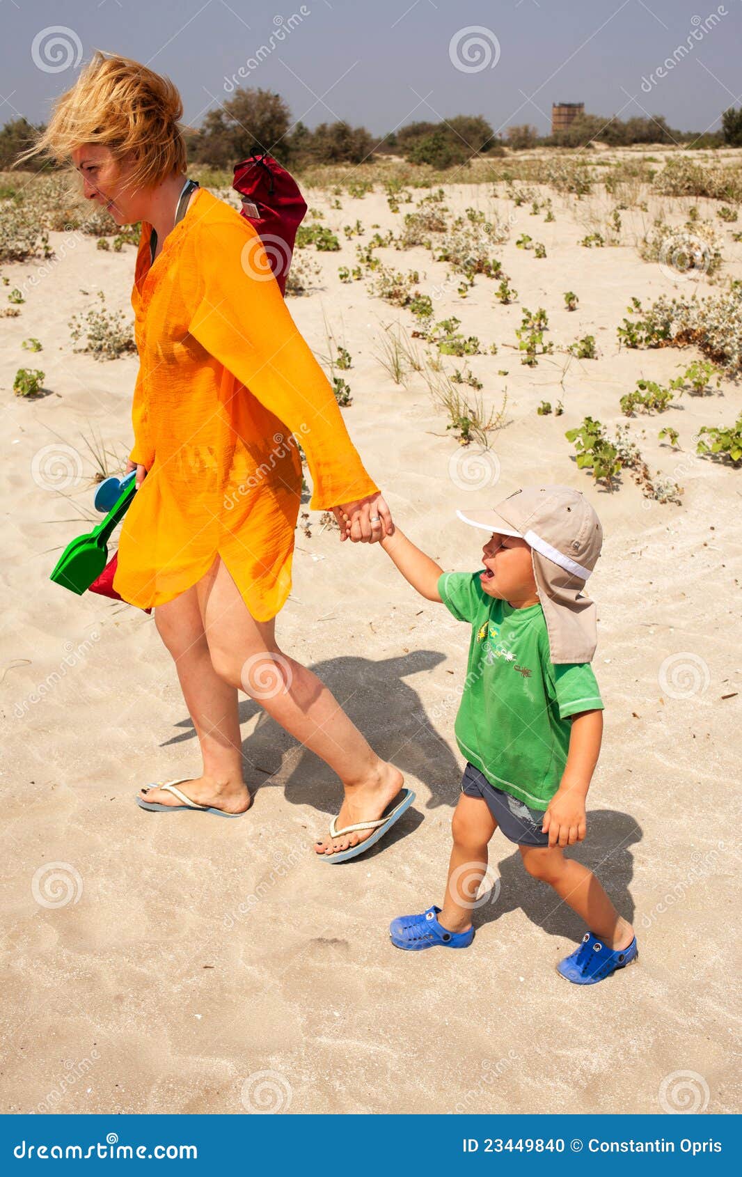 Bambino che lascia gridare della spiaggia. Bambino gridante che lascia spiaggia con la sua madre, essendo triste