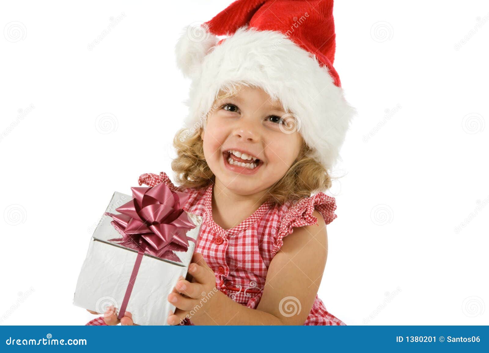 Bambino con il presente. Una piccola ragazza con un cappello di natale e un presente