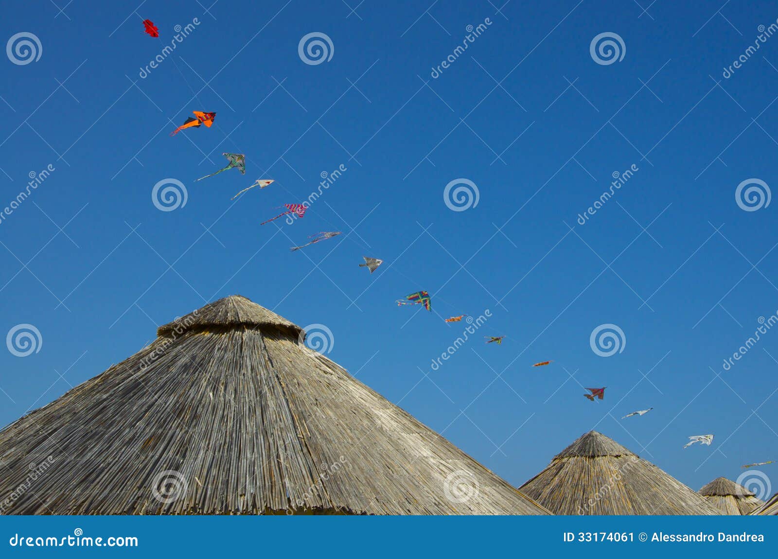Bamboo Beach Umbrella and Kites Over a Blue Sky Stock Image Image of