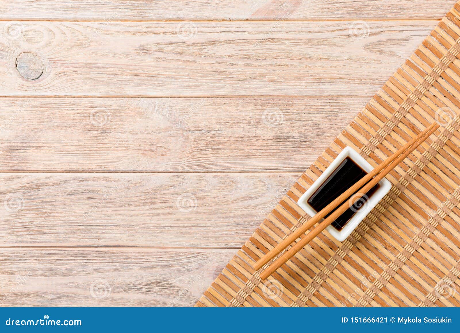 Bamboo Mat And Soy Sauce With Sushi Chopsticks On Wooden Table