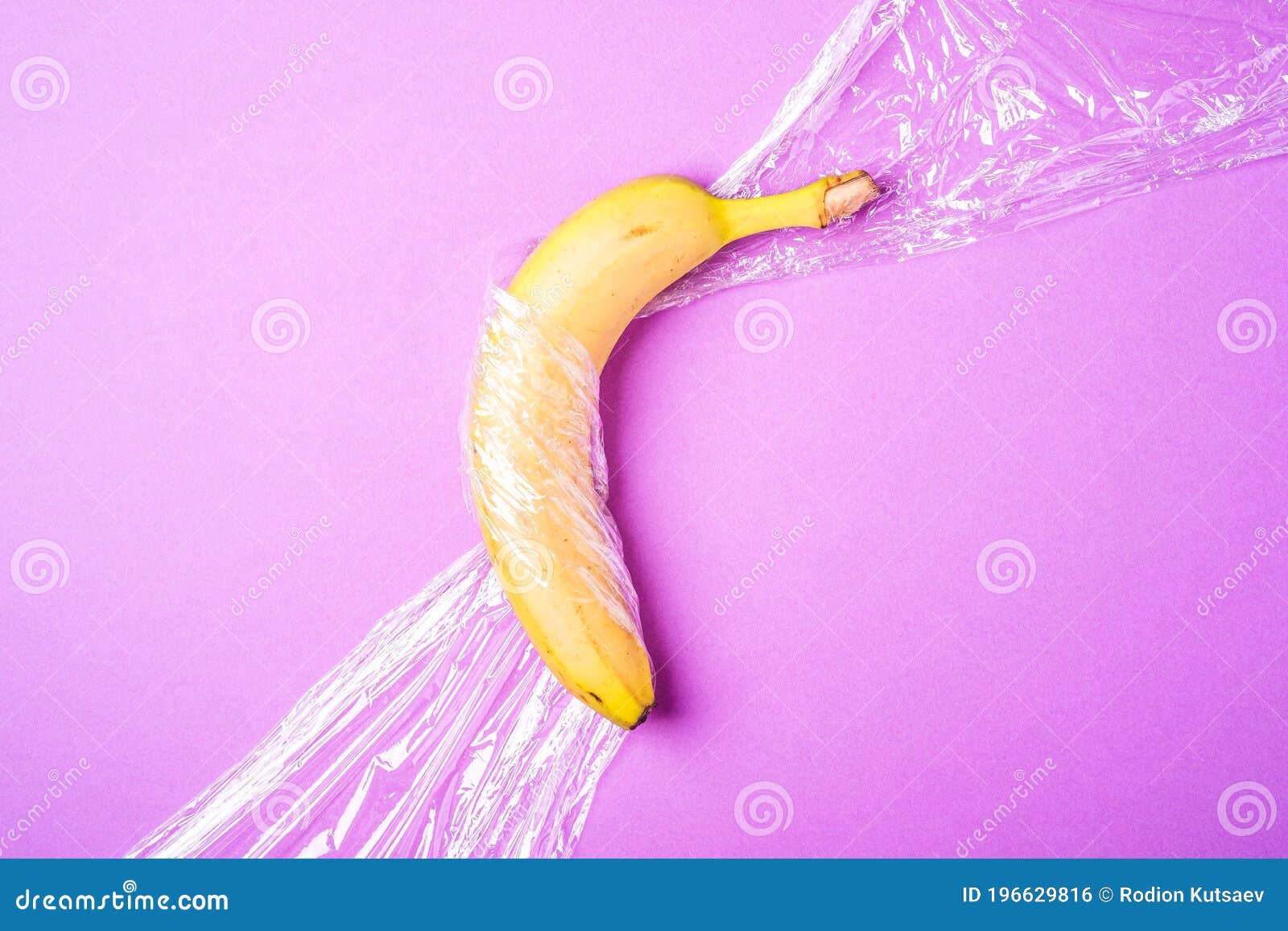 Banana Fruit Wrapped in Stretch Wrap Plastic on Pink Background