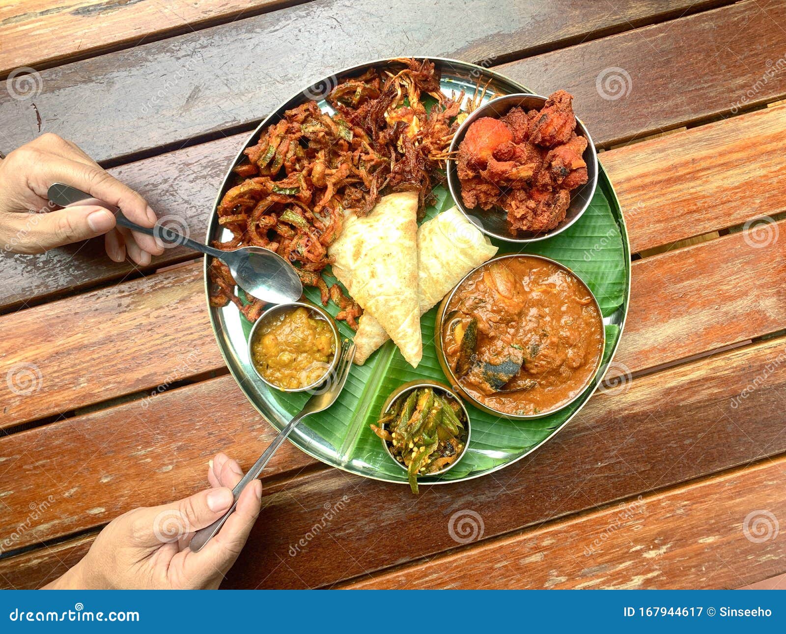 banana leaf meal, consists of fried chicken, curry seafood, vegetables, canai and etc