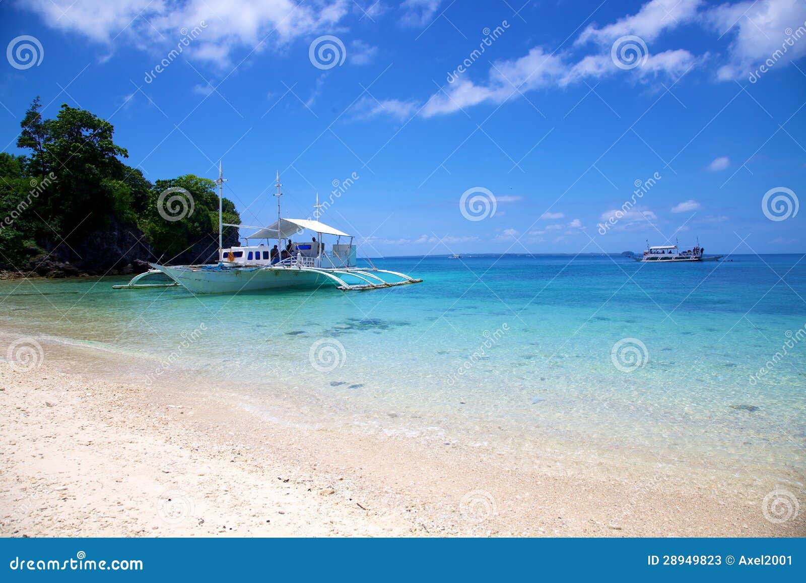 banca boat on white sand tropical beach on malapascua island, philippines
