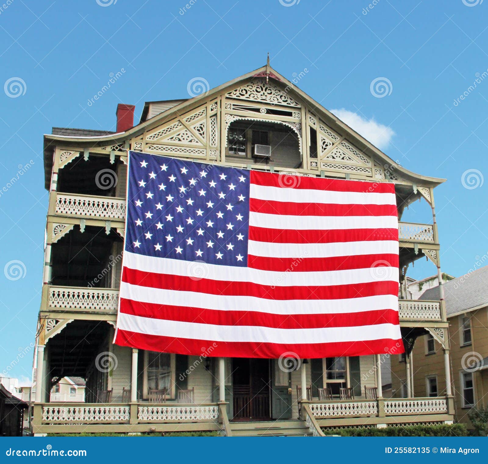 Bandeira americana do grande tamanho que pendura em uma parte dianteira de uma casa.