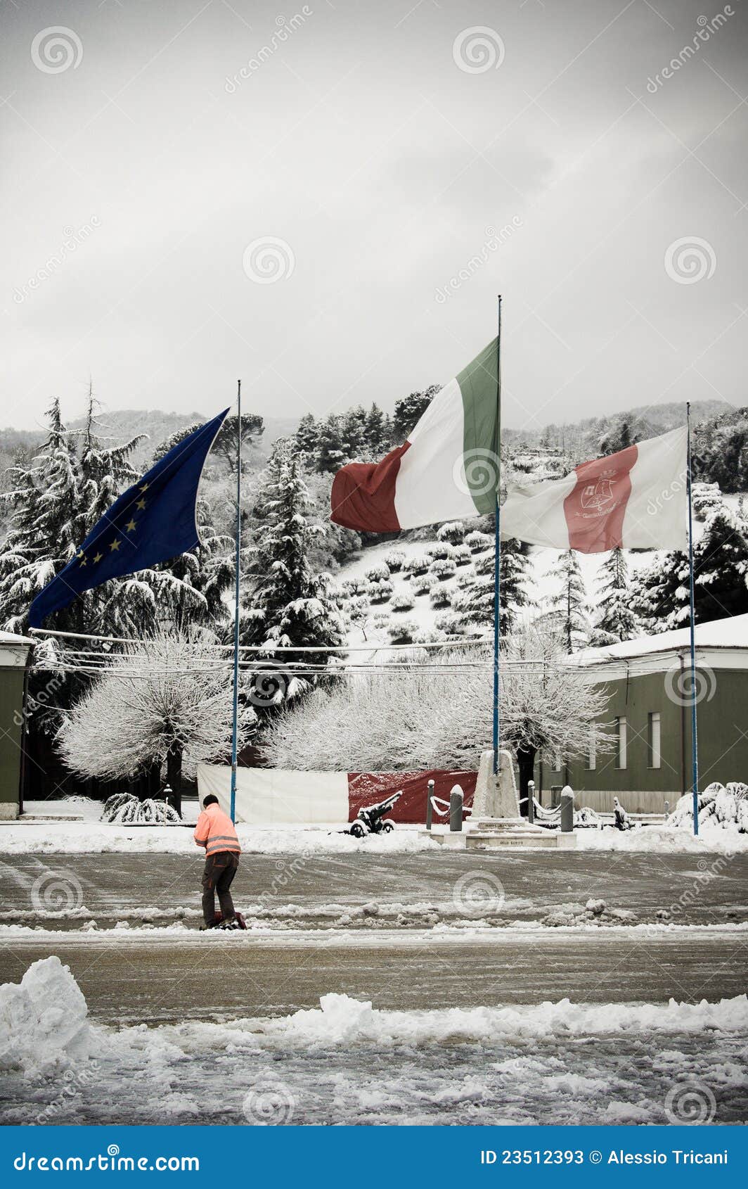 Bandeira de formação do italiano de 235 voluntários do regimento. Ascoli Piceno, Italy - o regimento do treinamento de Â° do 02:235 de fevereiro oferece Piceno o quadrado principal da base com a bandeira italiana, o soldado dois é prepara o solo e limpa aquele do gelo. Fevereiro 02, 2012 em Ascoli Piceno, Italy.