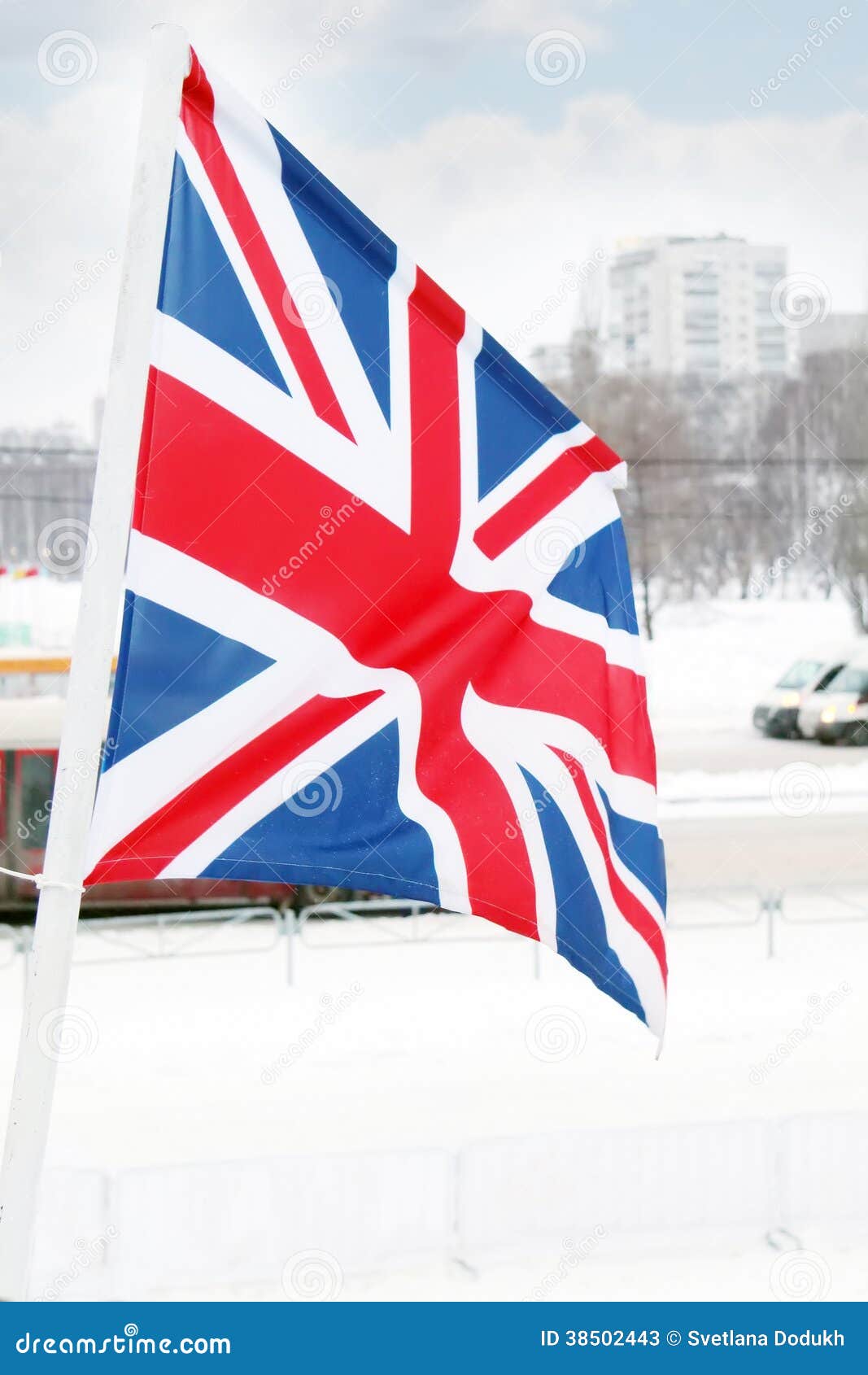 Bandeira de Reino Unido no vento no inverno. Bandeira de Reino Unido no vento no dia nebuloso do inverno na rua da cidade