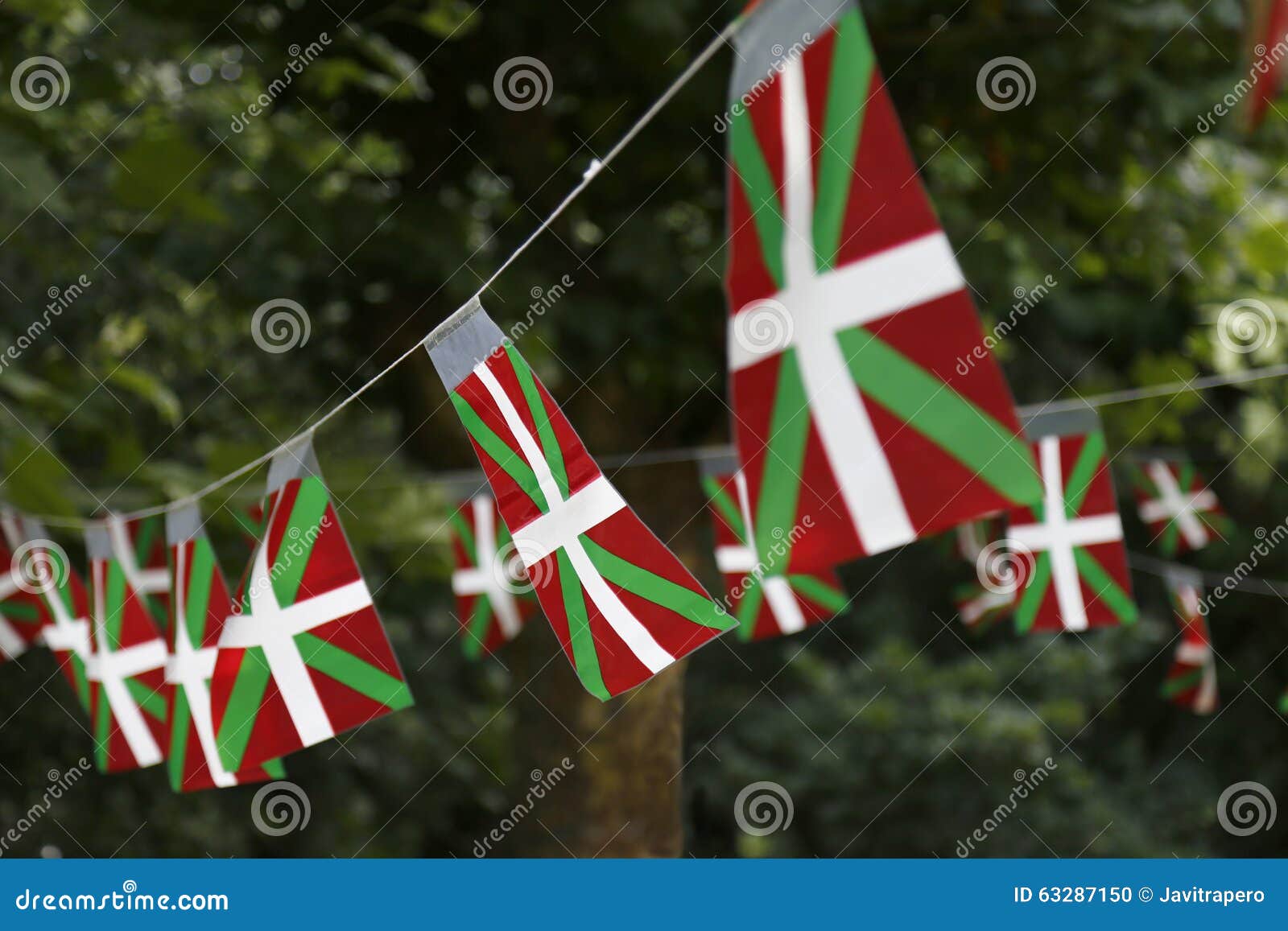 Bandeiras de país Basque que voam em um parque com árvores