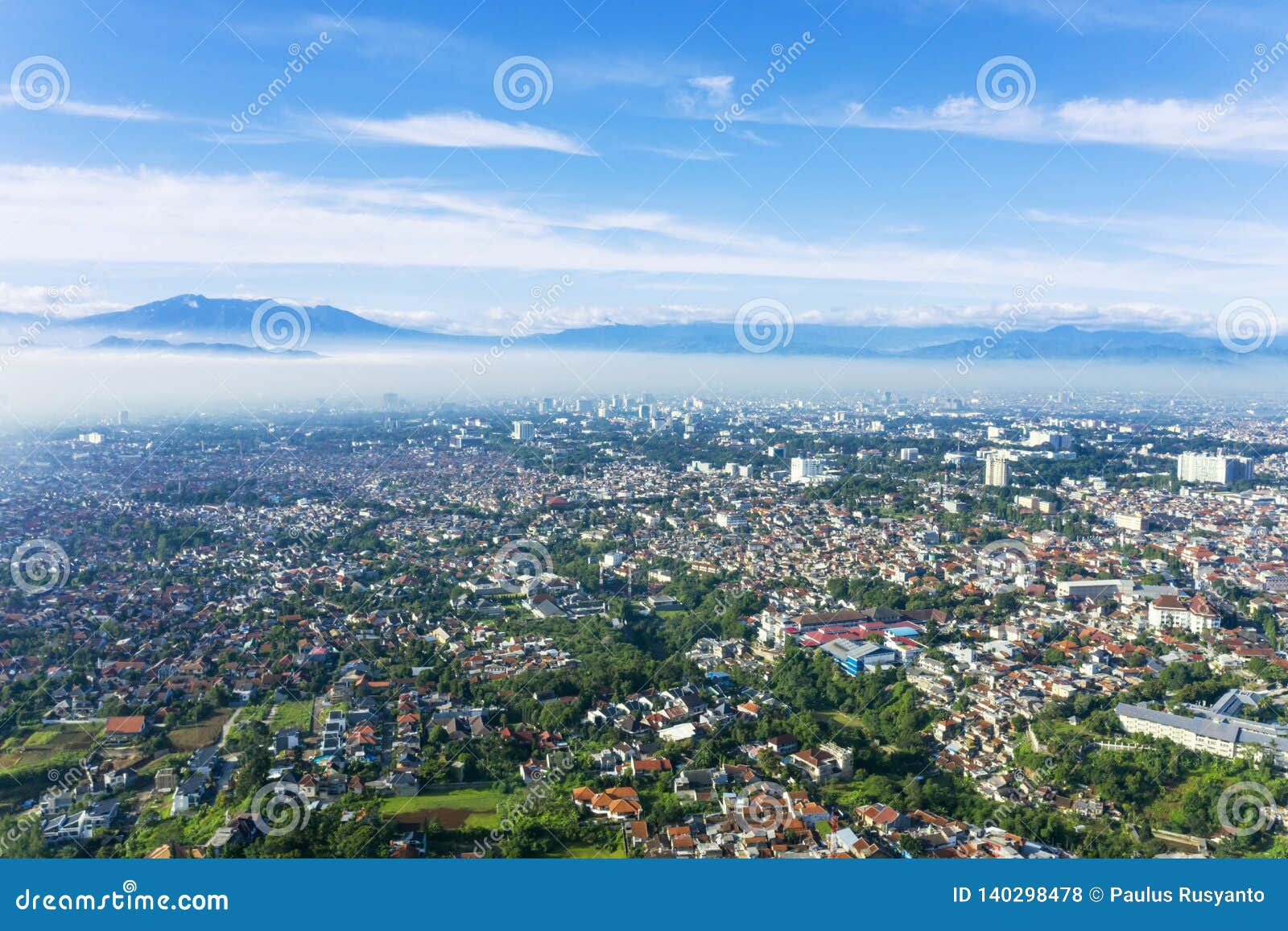 bandung city with crowd houses at misty morning