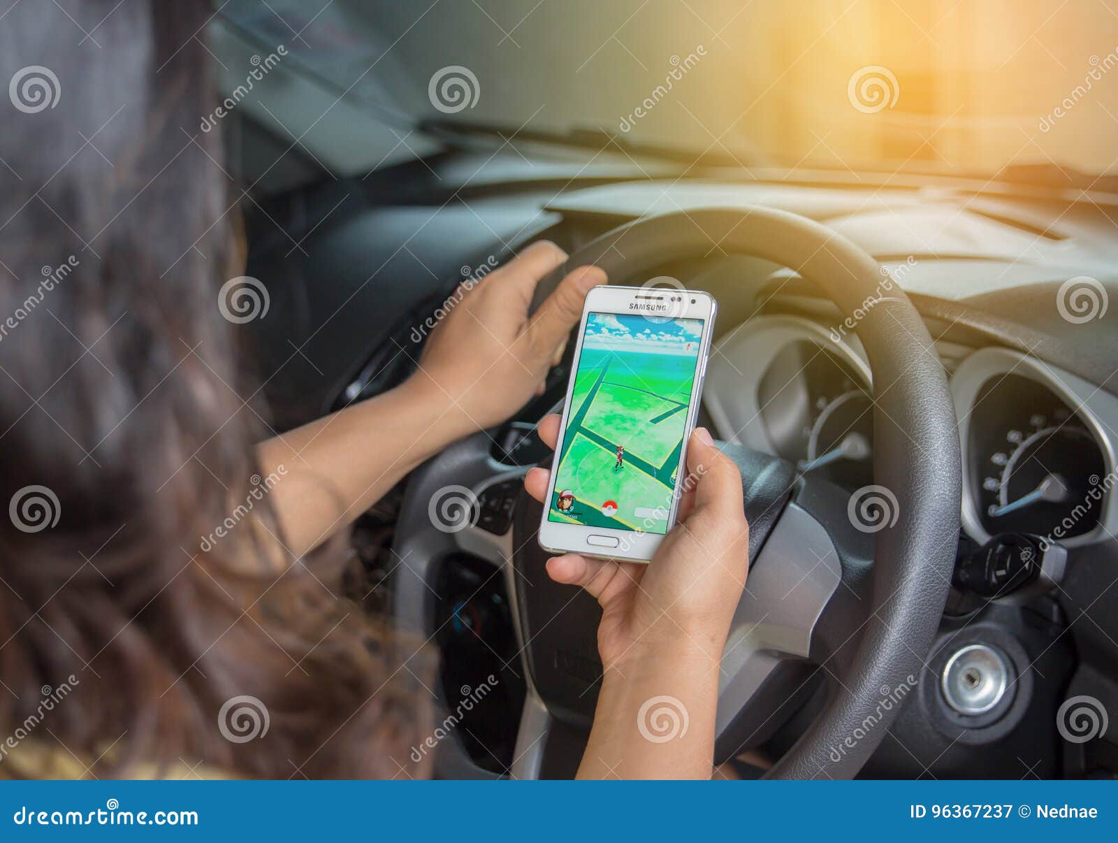 Woman sitting in a car and playing a Pokemon Go game Stock Photo - Alamy