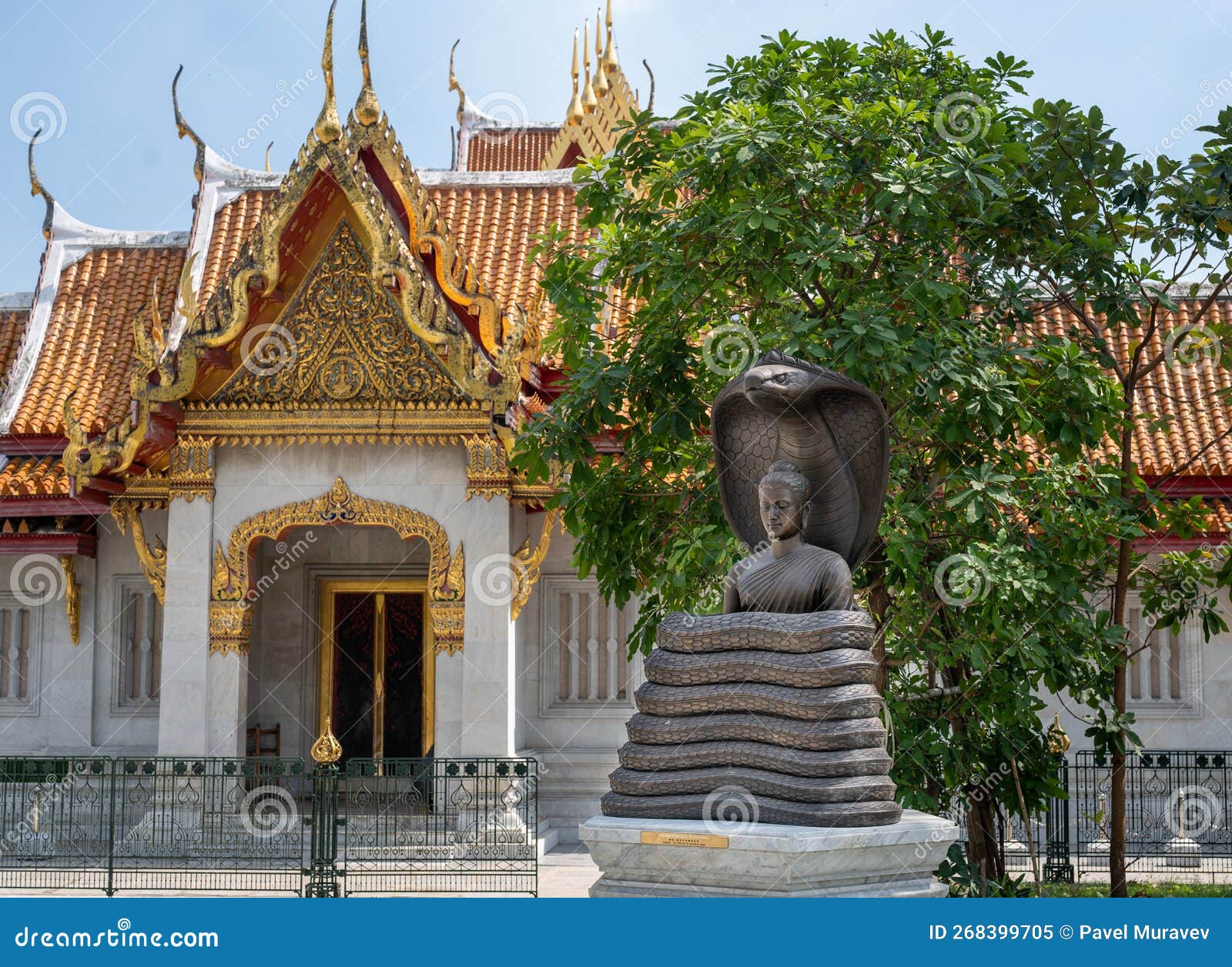 bangkok, thailand - february 04, 2023: bronze buddha statue entwined with cobra