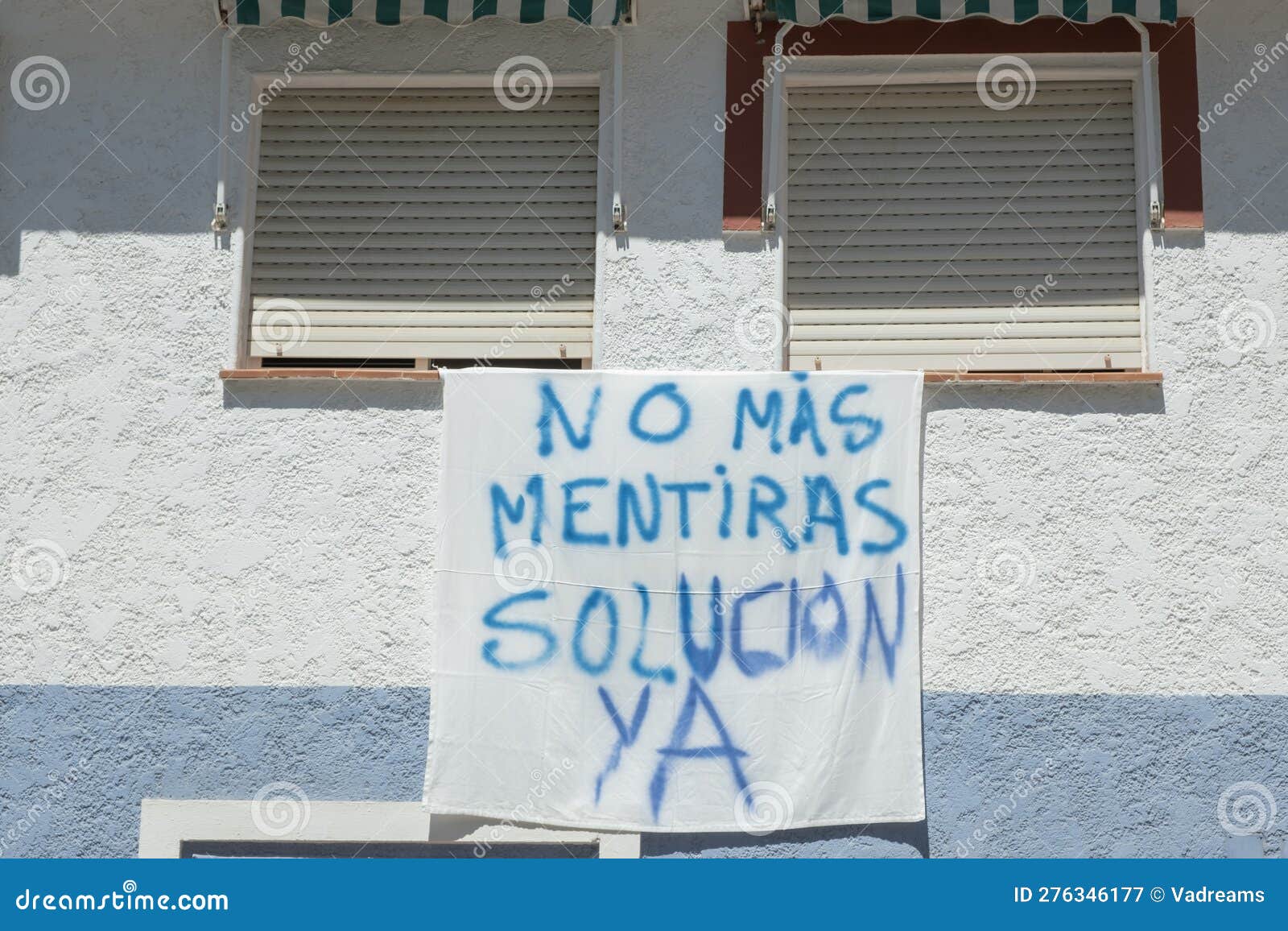 banner on building wall with spanish words no mas mentiras, solucion ya. people protest, disagreement with local