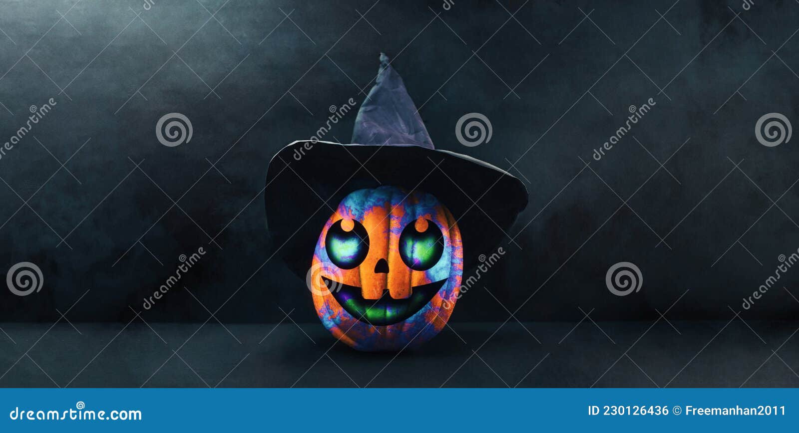 banner with carved jack-o-lantern. a decorated multicolored pumpkin in a black witch's hat on black background with copy