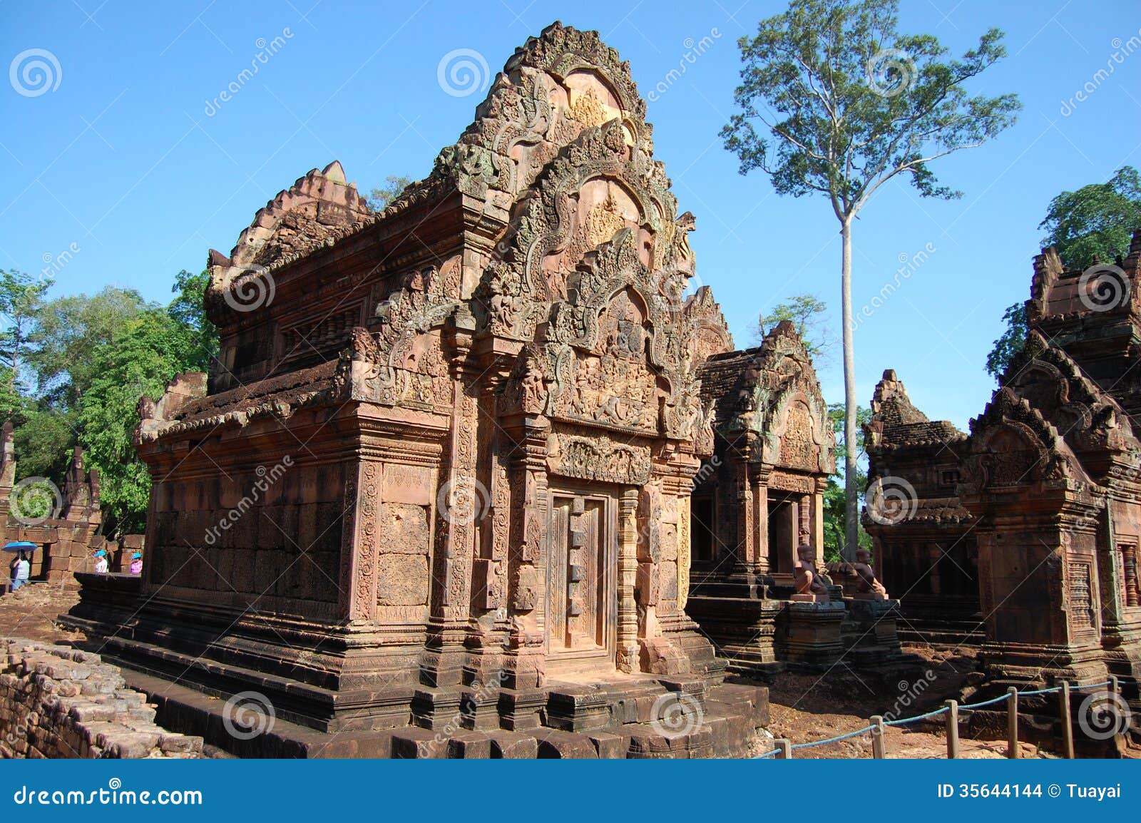 Banteay Srei major temple at Angkor Wat. Banteay Srei or Banteay Srey is a 10th century Cambodian temple dedicated to the Hindu god Shiva. Located in the area of Angkor in Cambodia. It lies near the hill of Phnom Dei, 25 km (16 mi) north-east of the main group of temples that once belonged to the medieval capitals of Yasodharapura and Angkor Thom. Banteay Srei is built largely of red sandstone, a medium that lends itself to the elaborate decorative wall carvings which are still observable today. The buildings themselves are miniature in scale, unusually so when measured by the standards of Angkorian construction. These factors have made the temple extremely popular with tourists, and have led to its being widely praised as a precious gem, or the jewel of Khmer art.