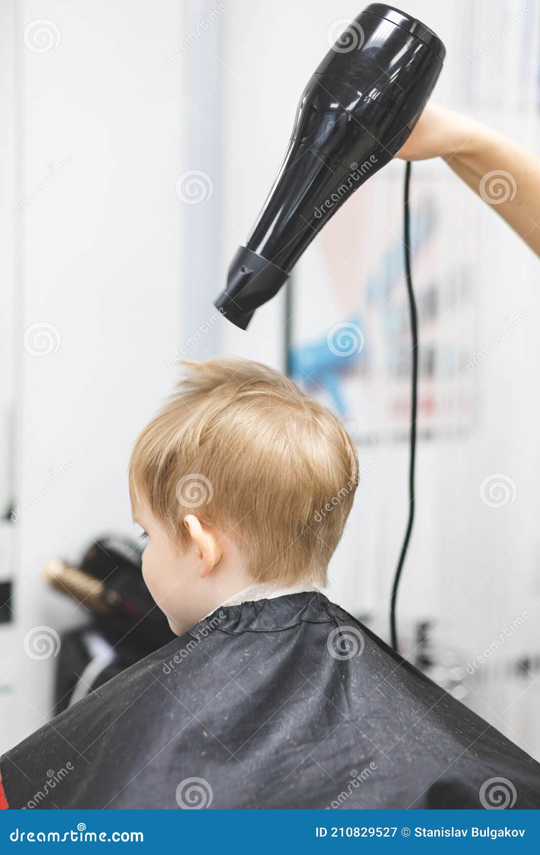 Cabeleireiro seca e modela o cabelo com um secador de cabelo no salão de  beleza