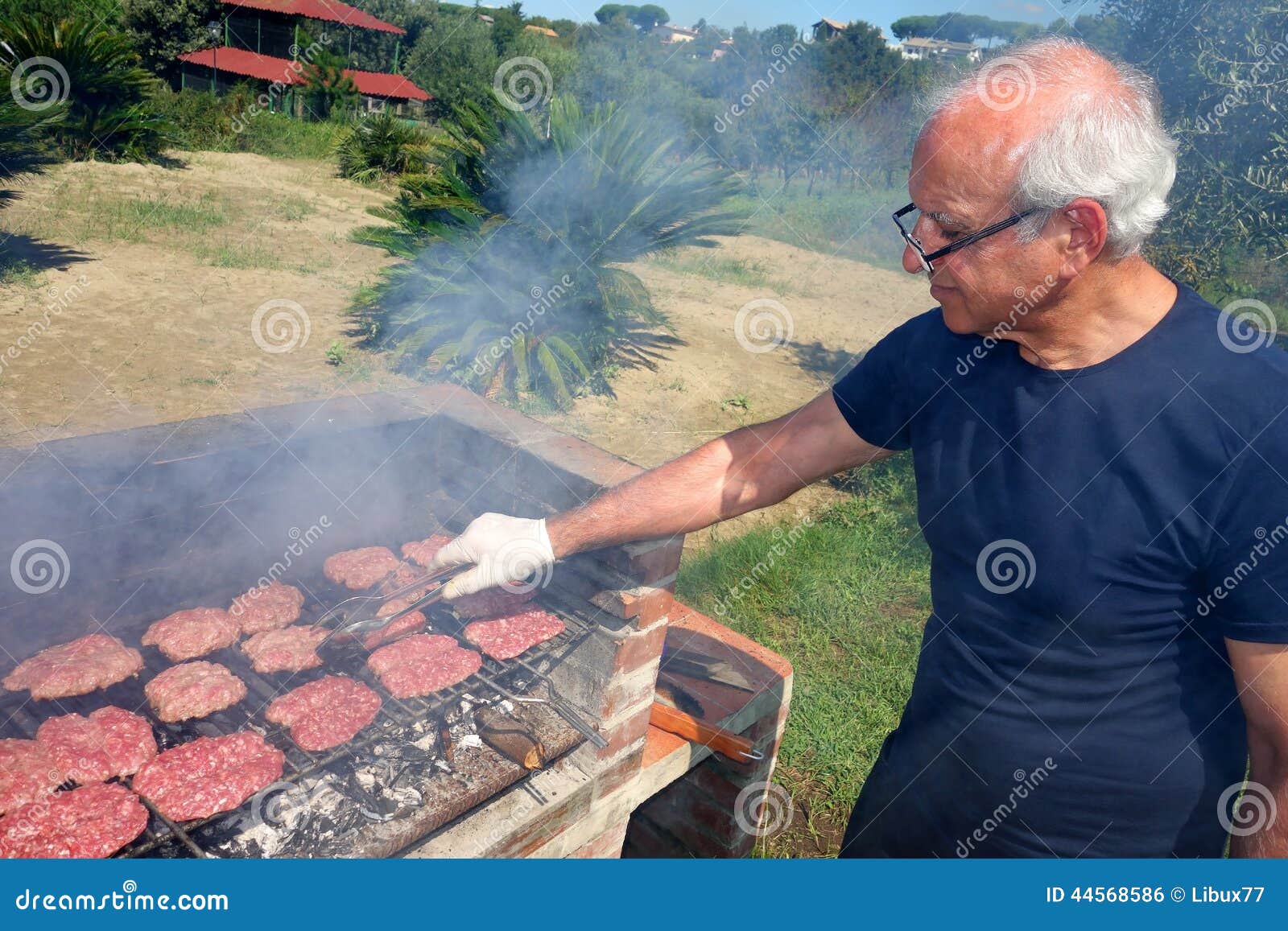 barbecue elderly skilled man cooking bbq meat