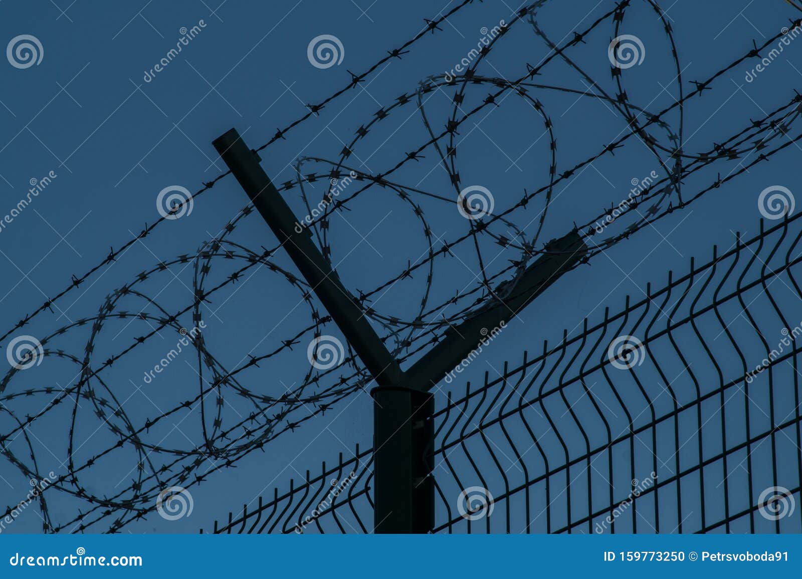 barbed wire steel fence against the immigrants in europe. restricted area at night.