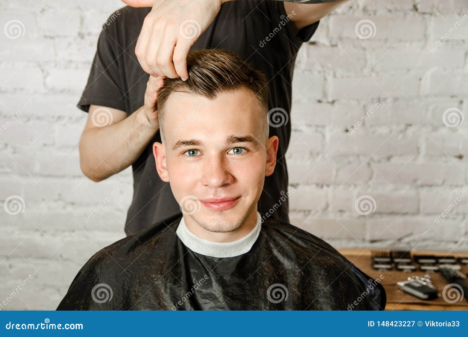 Barber Hand In Gloves Cut Hair And Hair Styling Young Man On A Brick