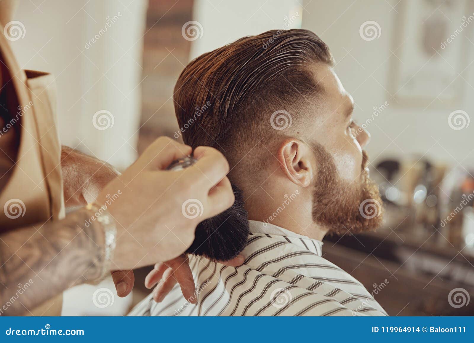 barber shakes hair off from the client`s neck